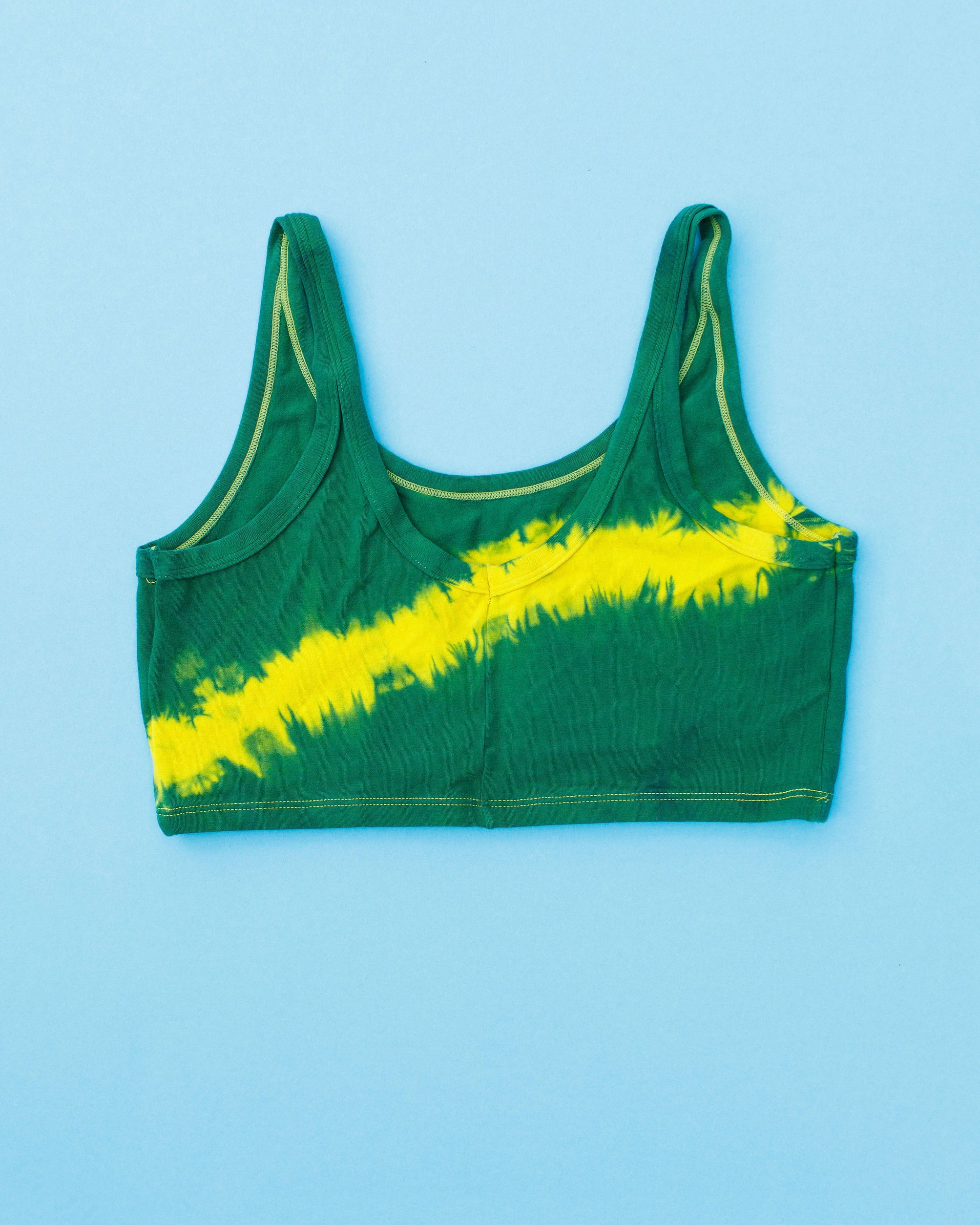 Flat lay of Thunderpants Longline Bra in Lightning Bolt Hand Dye - blue/green with yellow stripe.