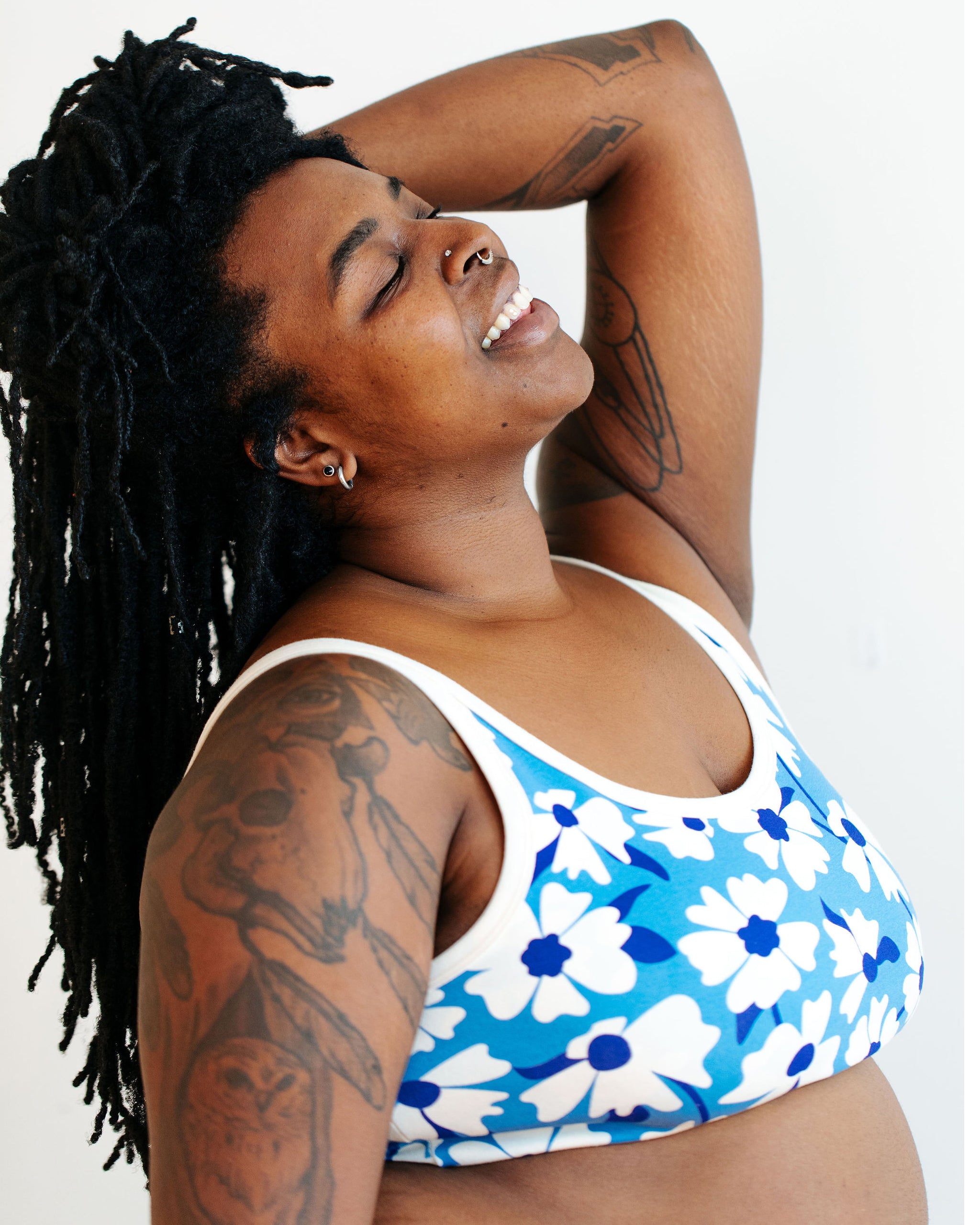 Model wearing Thunderpants Longline Bra in Moody Blooms - white and blue flowers with blue background.