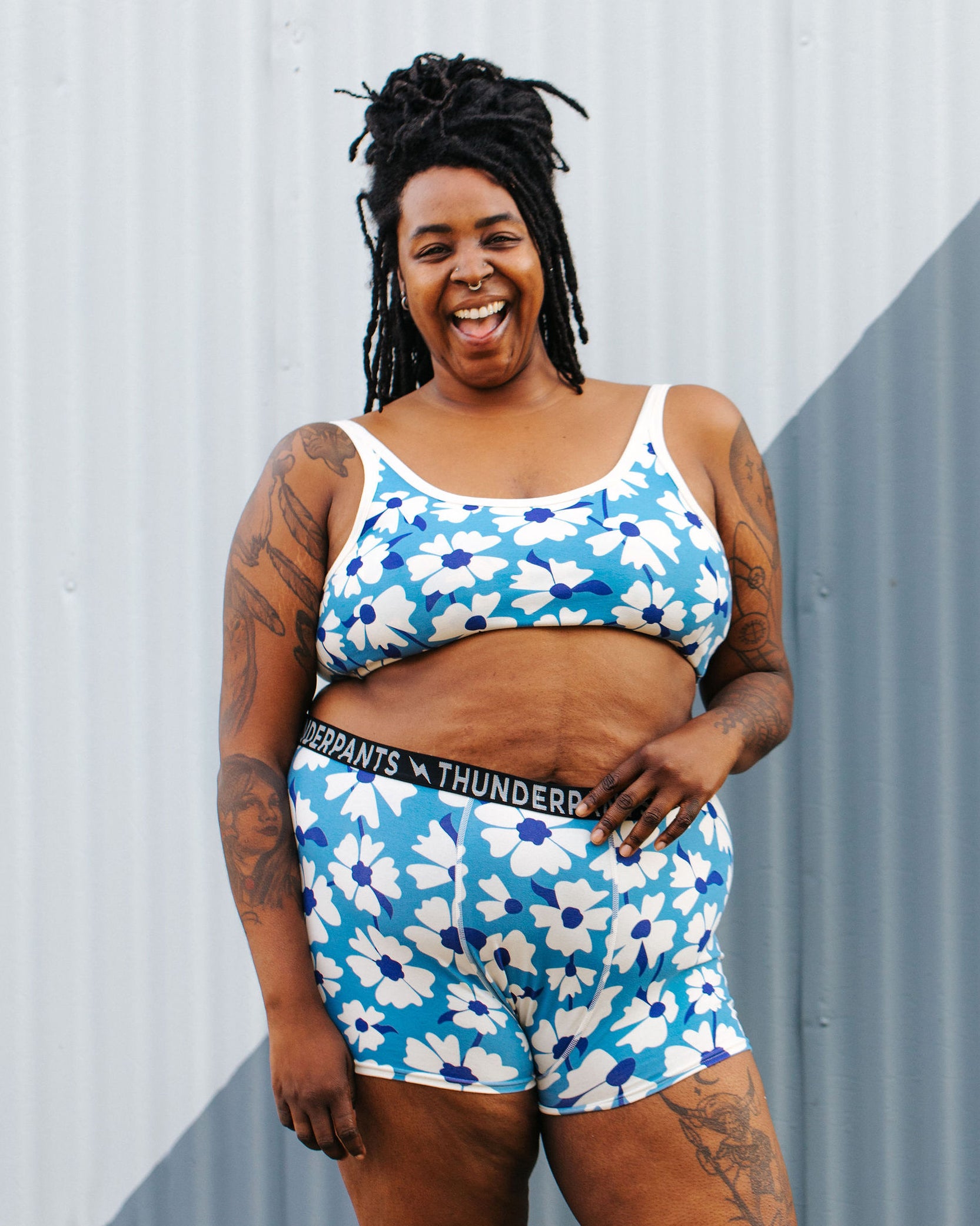 Model wearing Thunderpants Longline Bra and Boxer Brief style underwear in Moody Blooms - white and blue flowers with blue background.