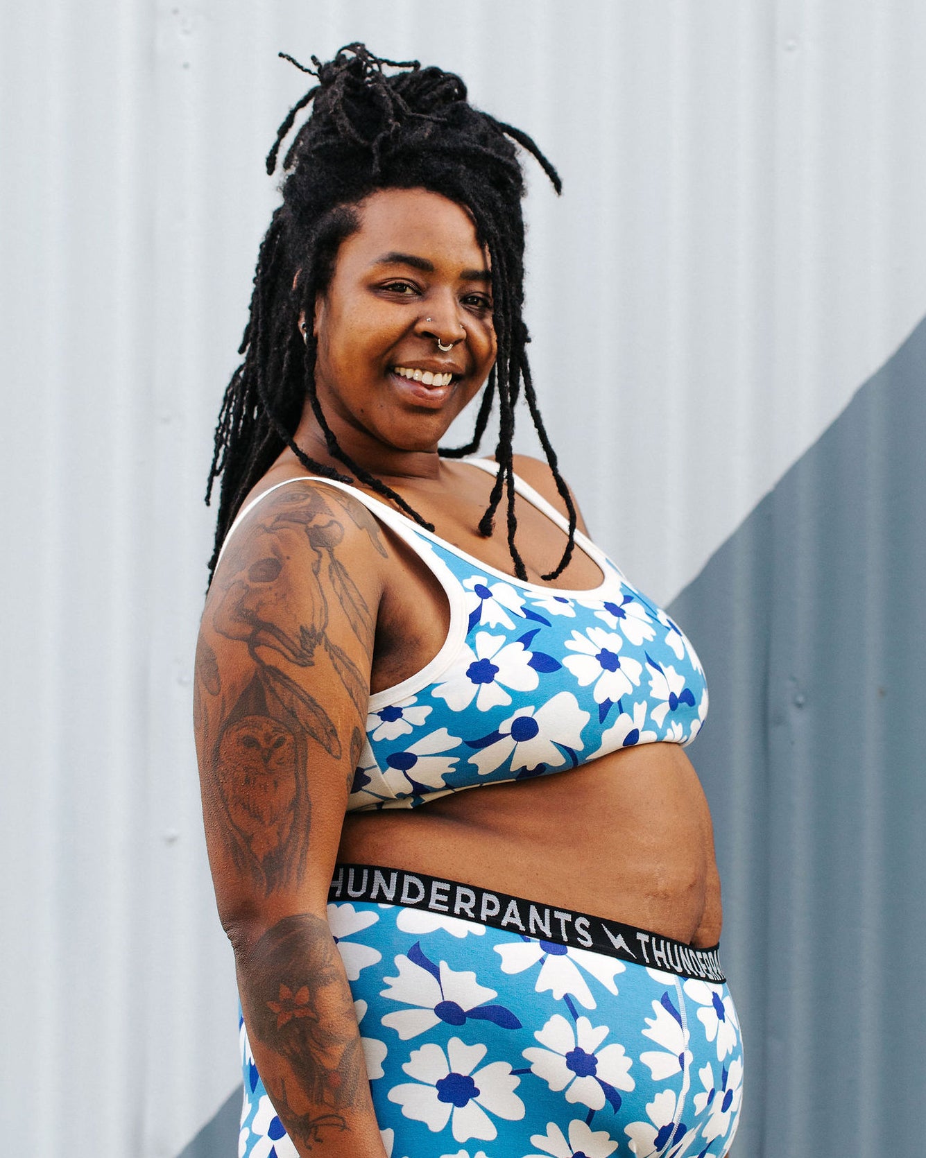 Model wearing Thunderpants Longline Bra in Moody Blooms - white and blue flowers with blue background.