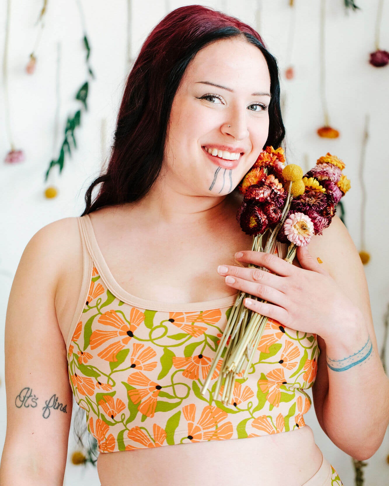 Model wearing Thundrpants Longline Bra in Secret Garden - orange flowers and green leaves.