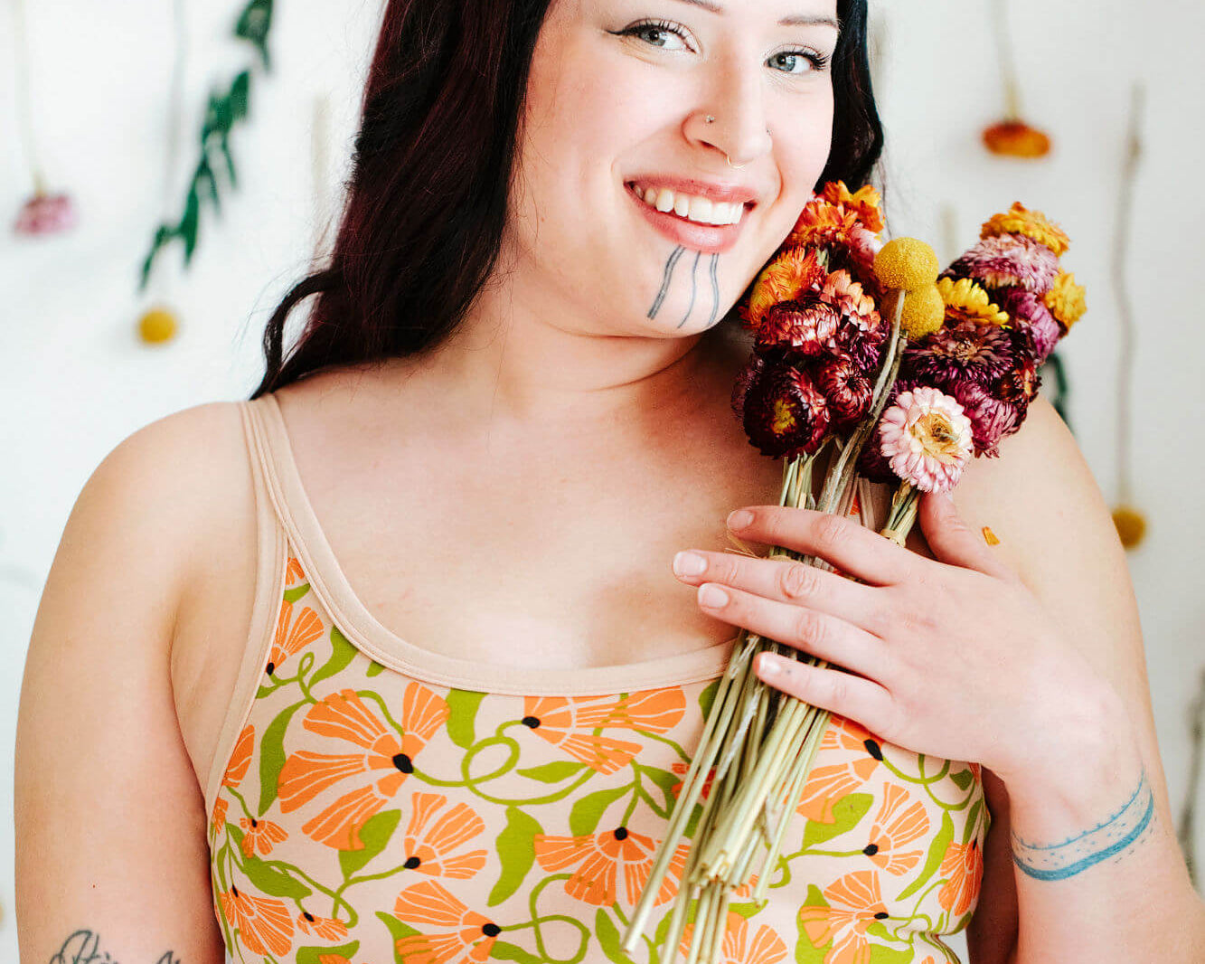 Model wearing Thundrpants Longline Bra in Secret Garden - orange flowers and green leaves.