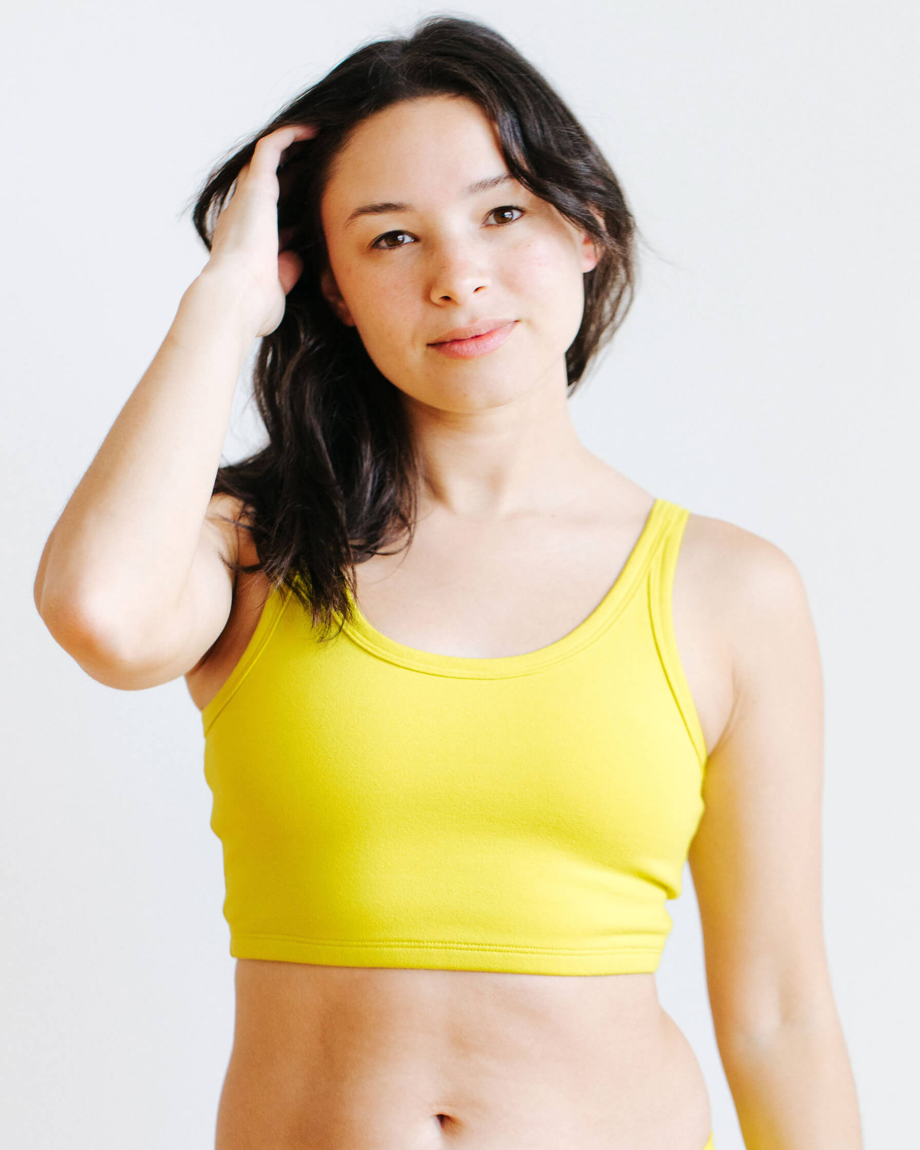 Model wearing Thunderpants Longline Bra in Star Fruit color - a chartreuse yellow.