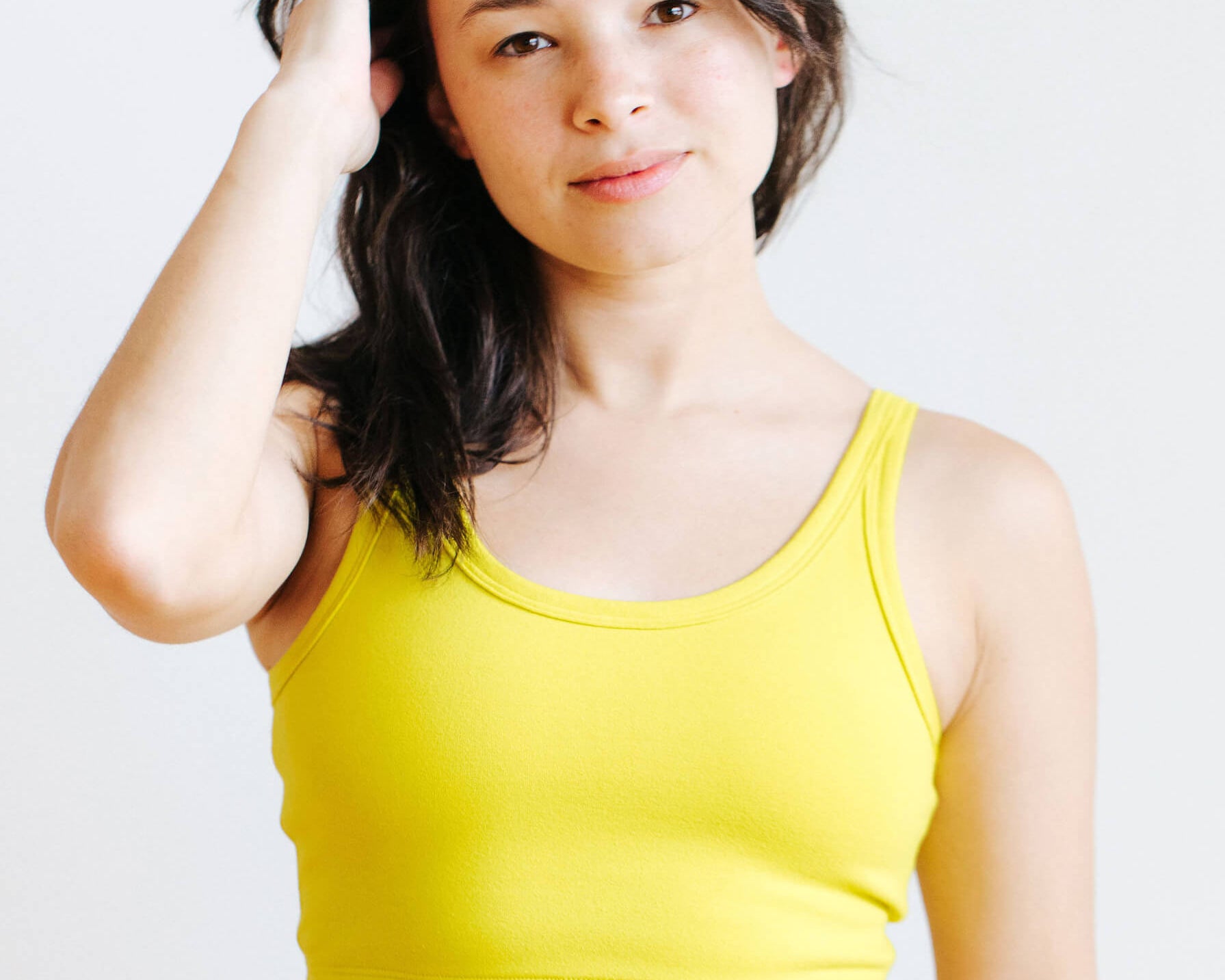Model wearing Thunderpants Longline Bra in Star Fruit color - a chartreuse yellow.