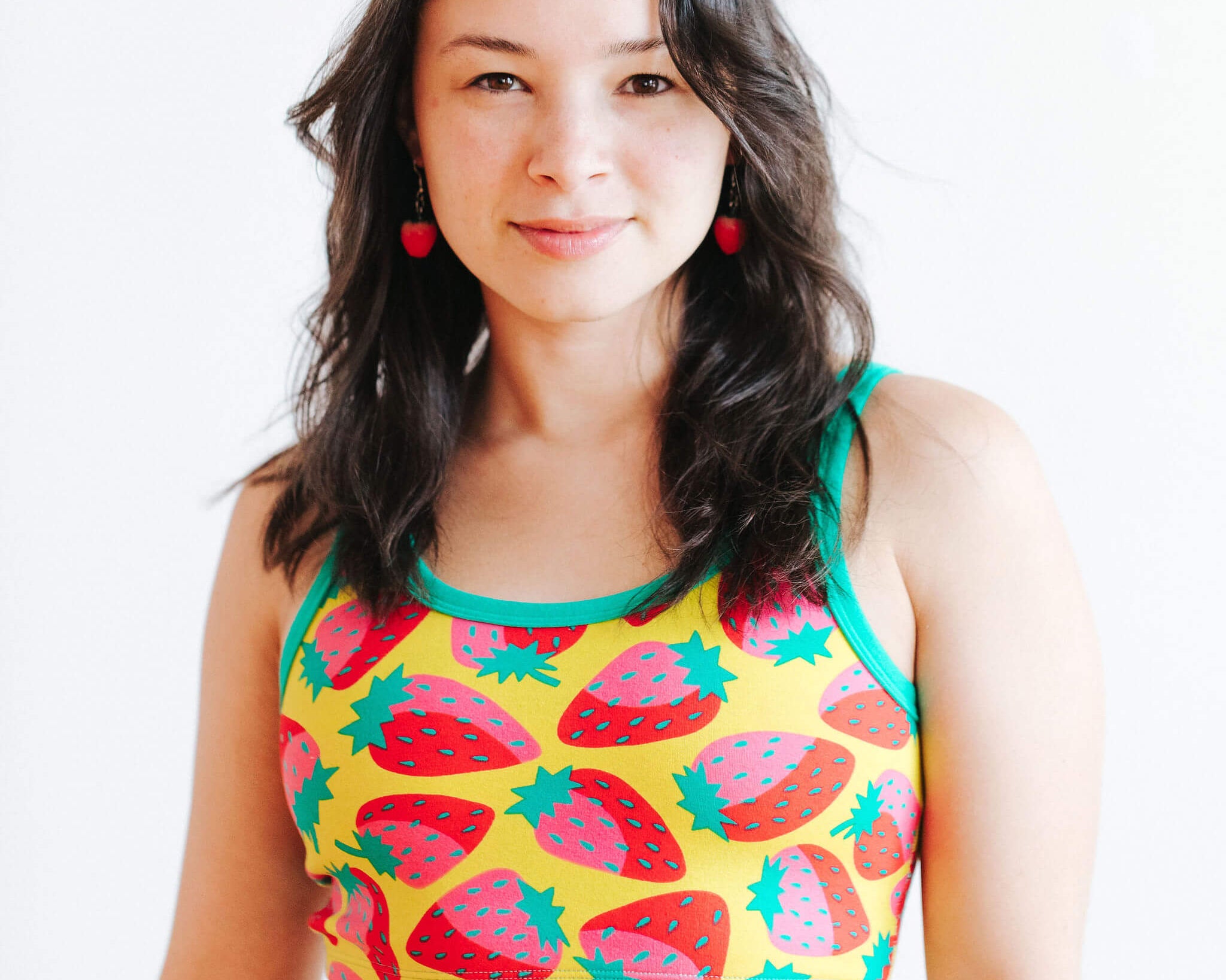 Model wearing Thunderpants Longline Bra in a Strawberry print - pink, red, and peacock green on chartreuse. 
