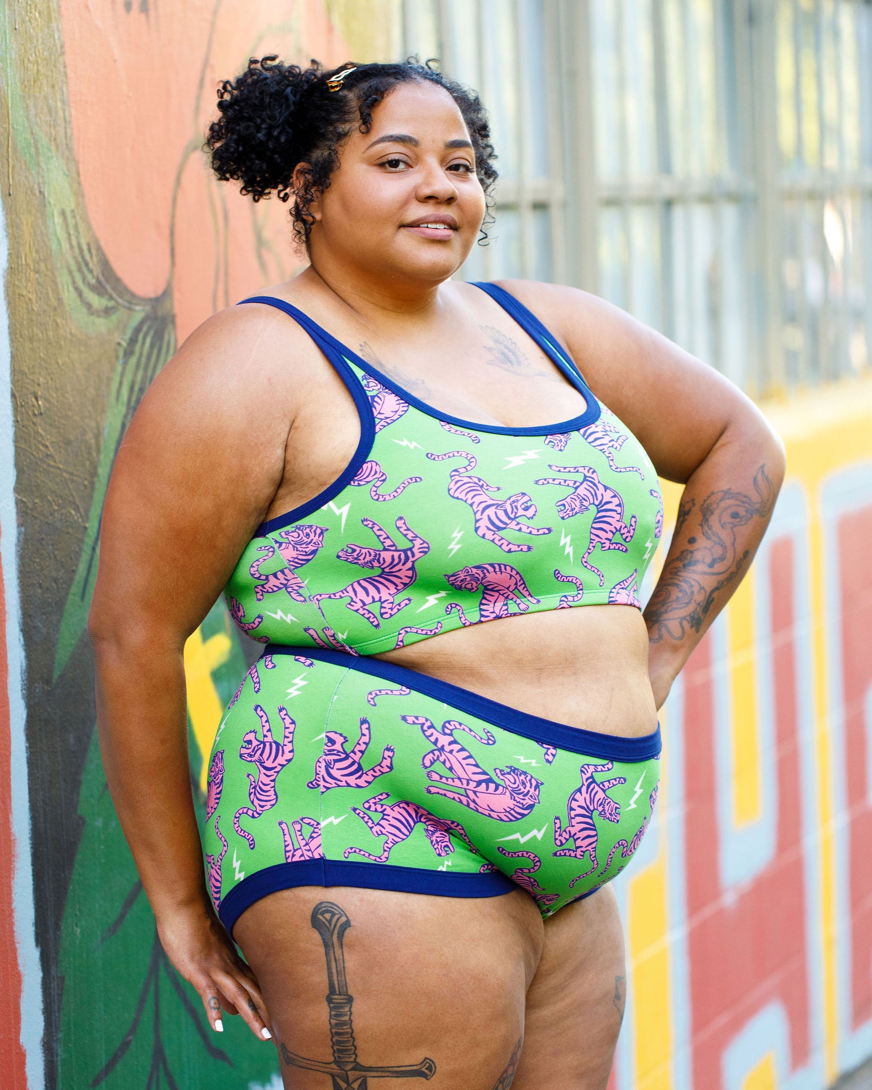 Model wearing Thunderpants organic cotton Longline Bra  and Original style underwear in Electric Tiger - green with pink and blue tigers and white lightning bolts.