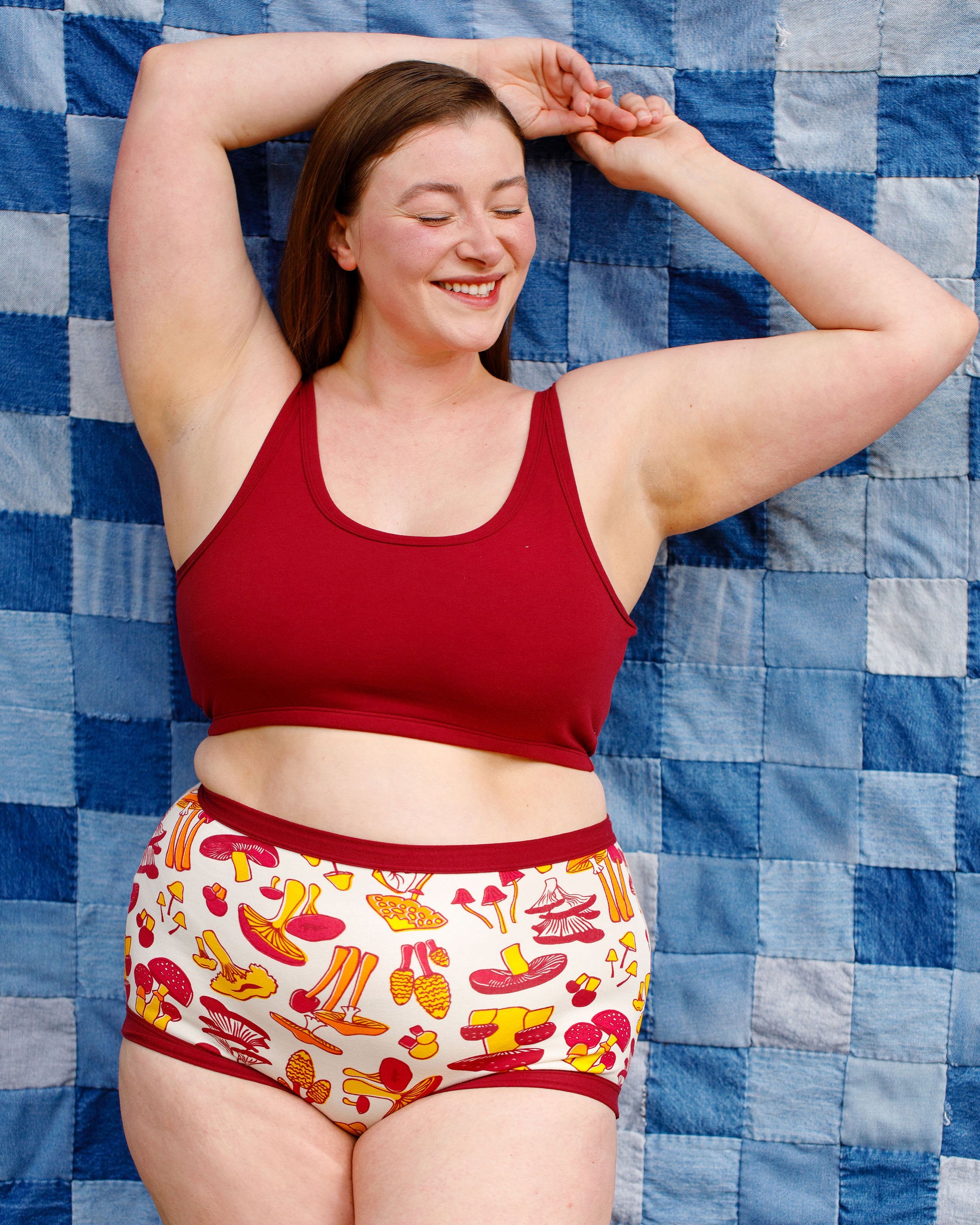 Model wearing Thunderpants Longline Bra in Cabern-YAY (a deep wine red color) and Sky Rise style underwear in a mushroom print.