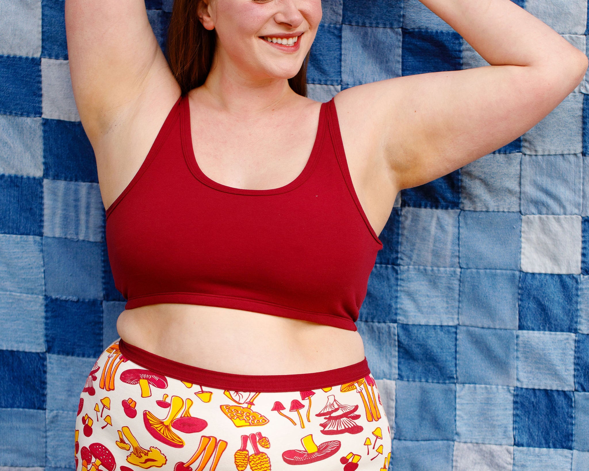 Model wearing Thunderpants Longline Bra in Cabern-YAY (a deep wine red color) and Sky Rise style underwear in a mushroom print.