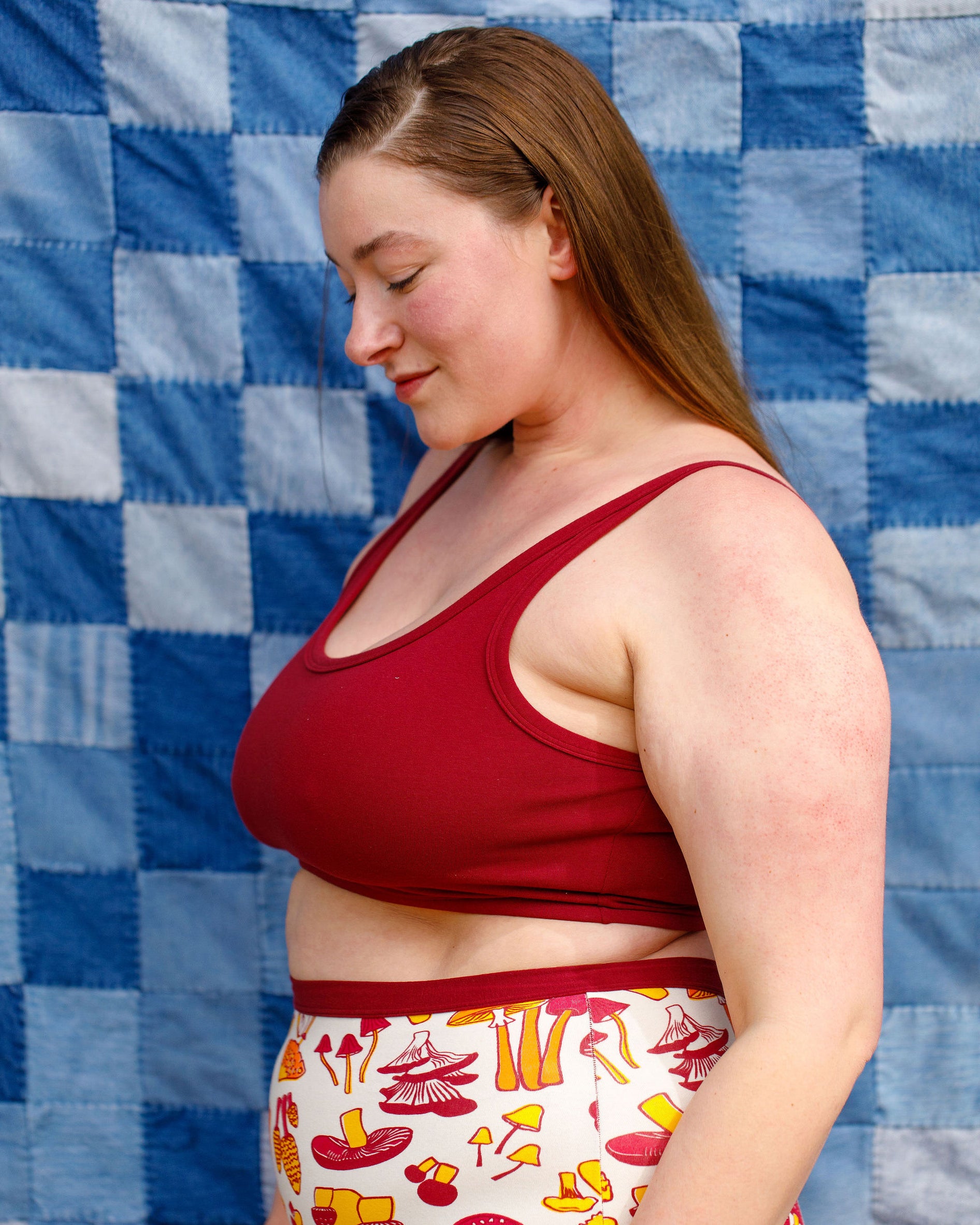 Model wearing Thunderpants Longline Bra in Cabern-YAY (a deep wine red color) and Sky Rise style underwear in a mushroom print.