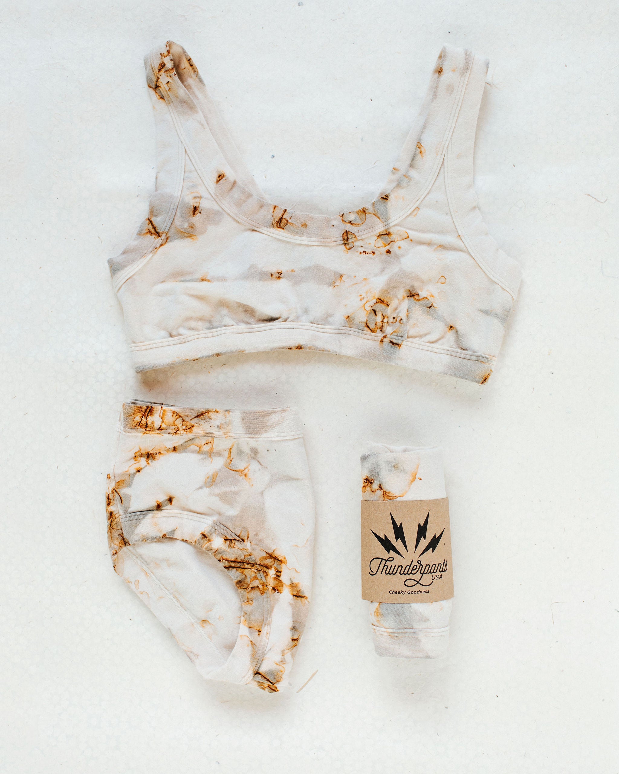 Flat lay of Thunderpants Hipster style underwear and Bralette in Mineral Rust Dye.