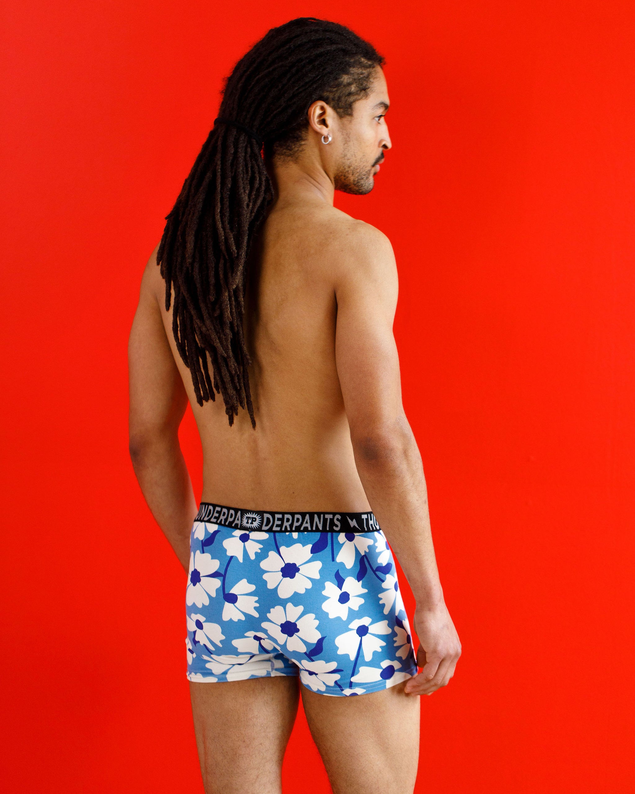 Male model wearing Thunderpants organic cotton Boxer Brief style underwear in a blue and white floral print.