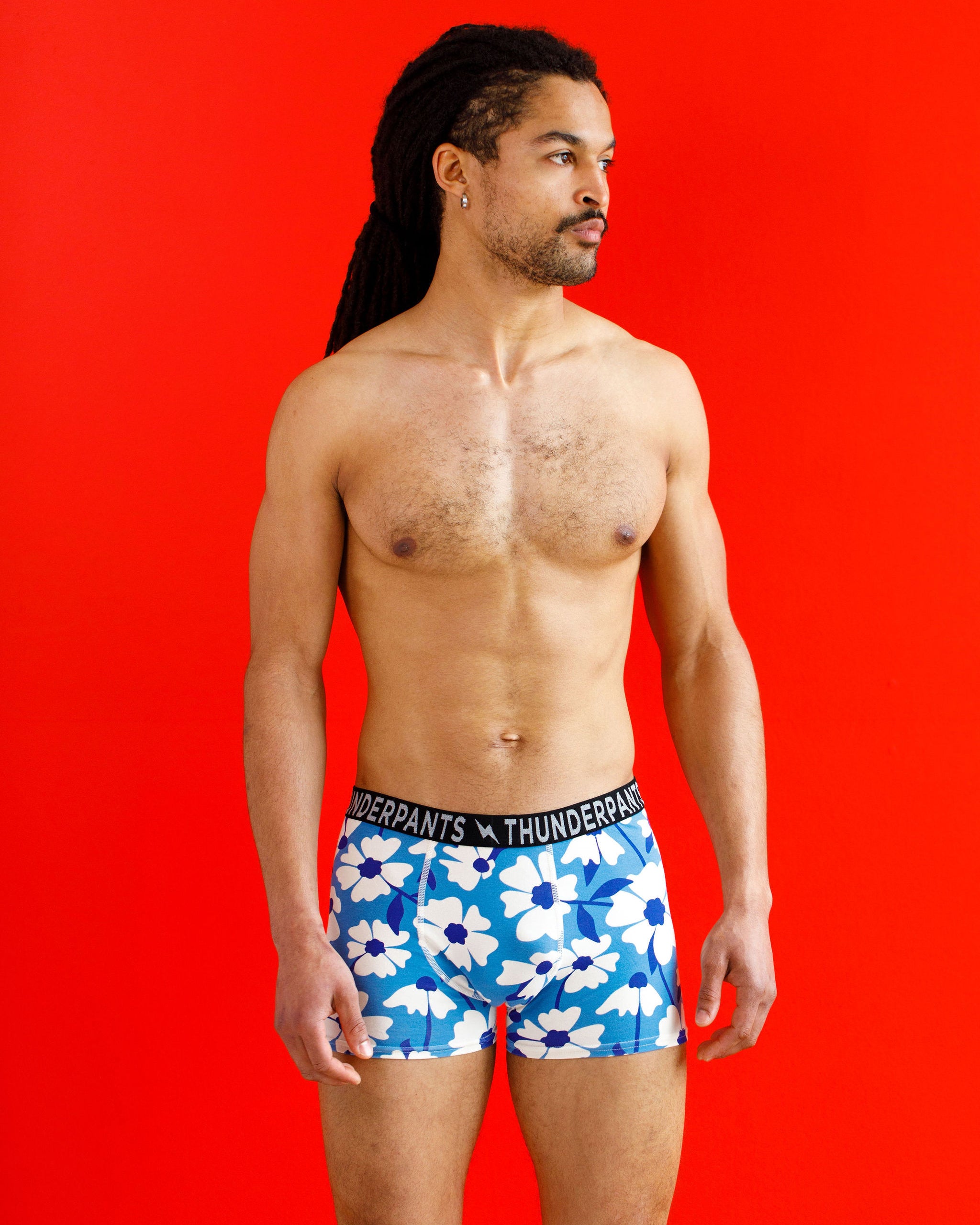 Male model wearing Thunderpants organic cotton Boxer Brief style underwear in a blue and white floral print.