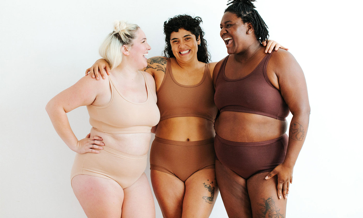 Three models wearing Thunderpants Original style underwear and Longline Bras in Pine Nut, Hazelnut, and Chestnut. 