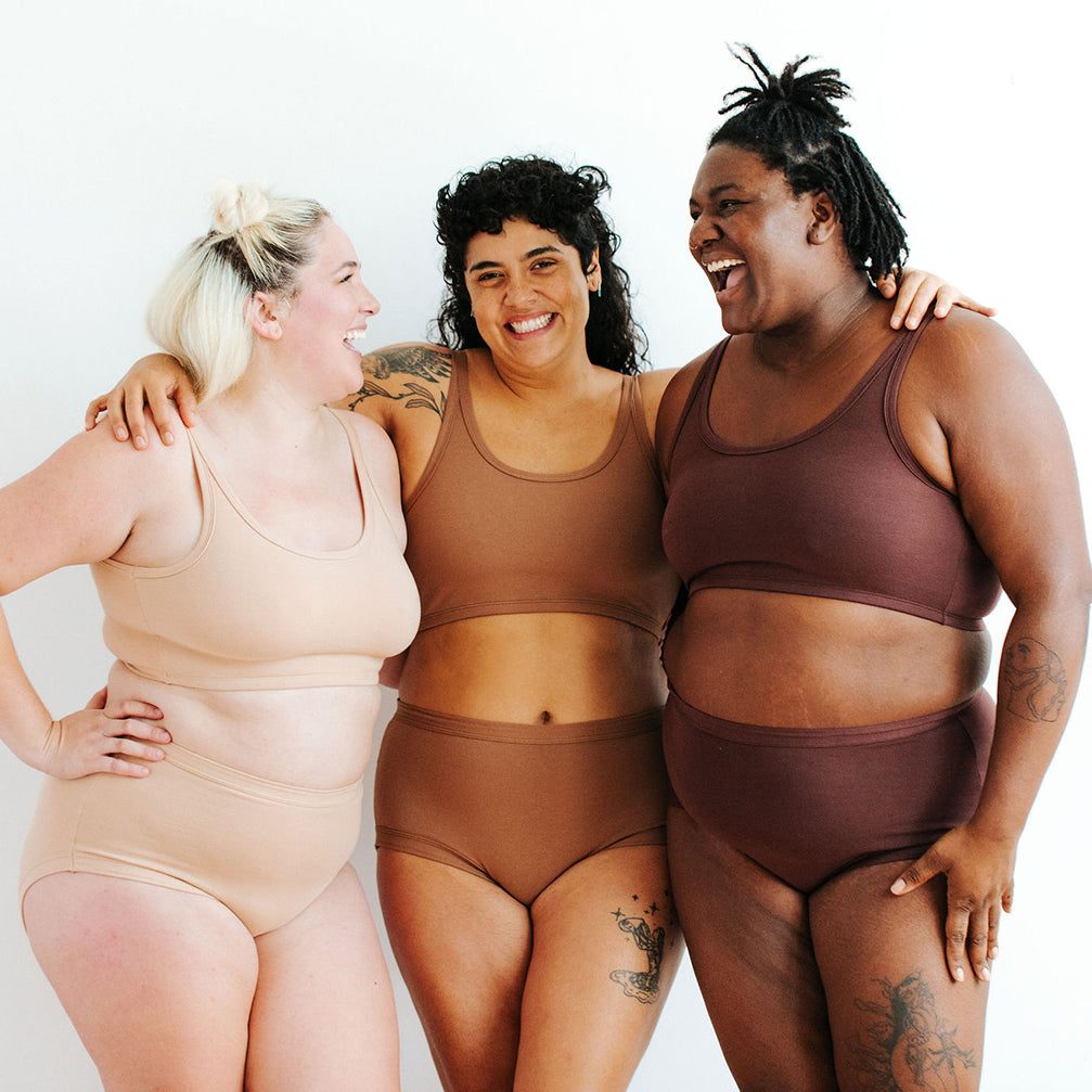 Three models wearing Thunderpants Original style underwear and Longline Bras in Pine Nut, Hazelnut, and Chestnut. 