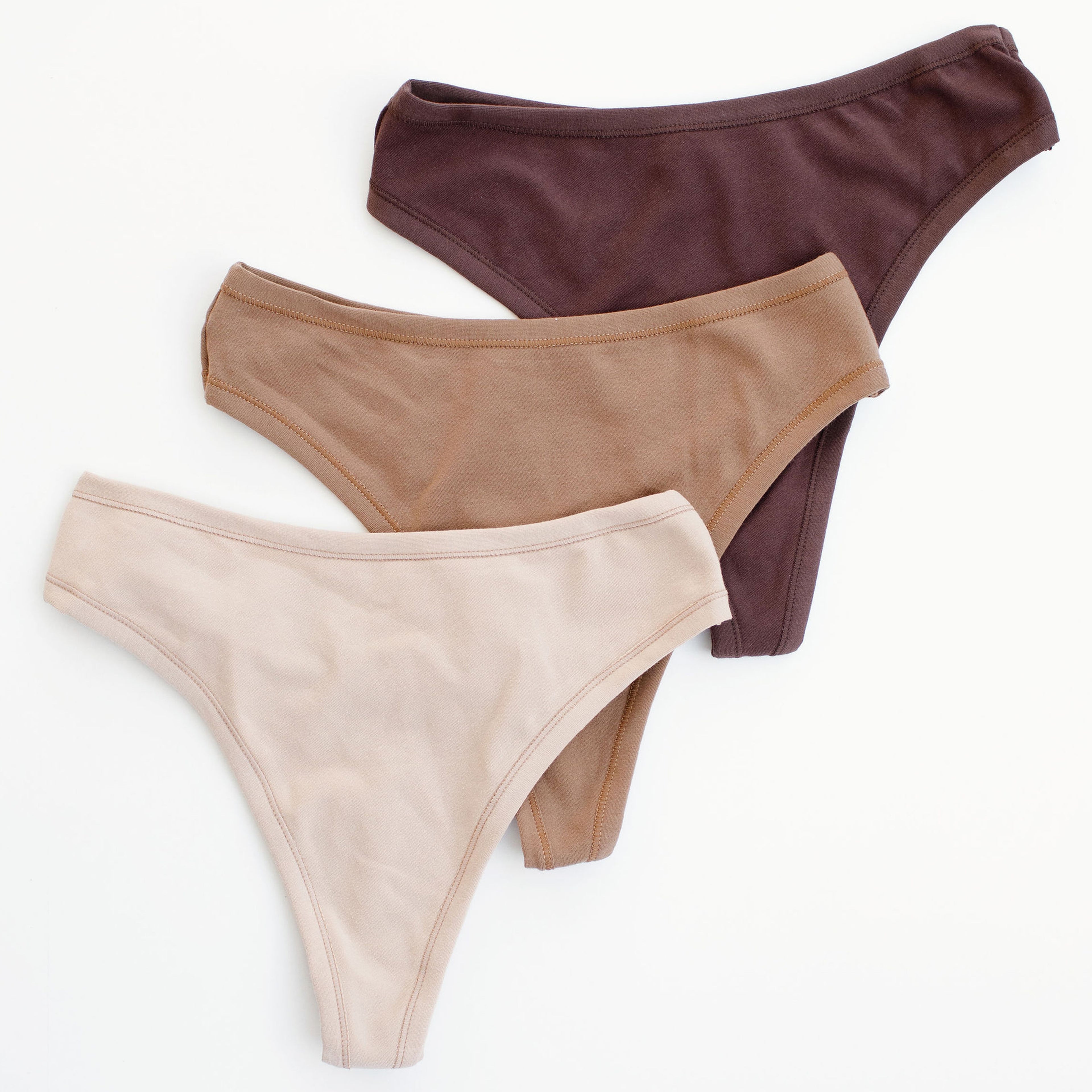 Flat lay of Thunderpants thong style underwear in Chestnut (dark brown), Hazelnut (mid brown), and Pine Nut (tan).