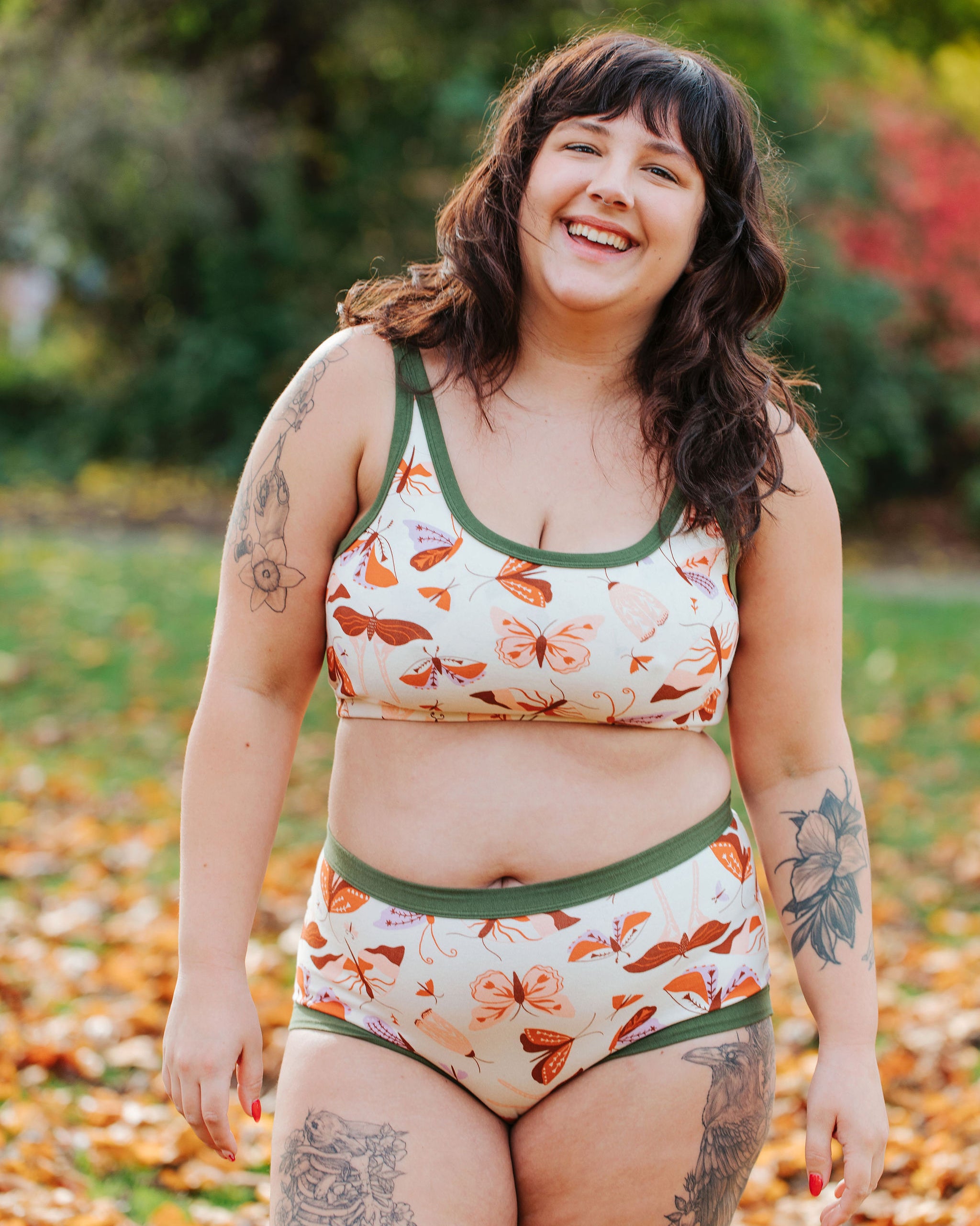 Model wearing Thunderpants Original style underwear and Longline Bra in Field Study: a moth print in red, orange, pink, and purple bound in green.