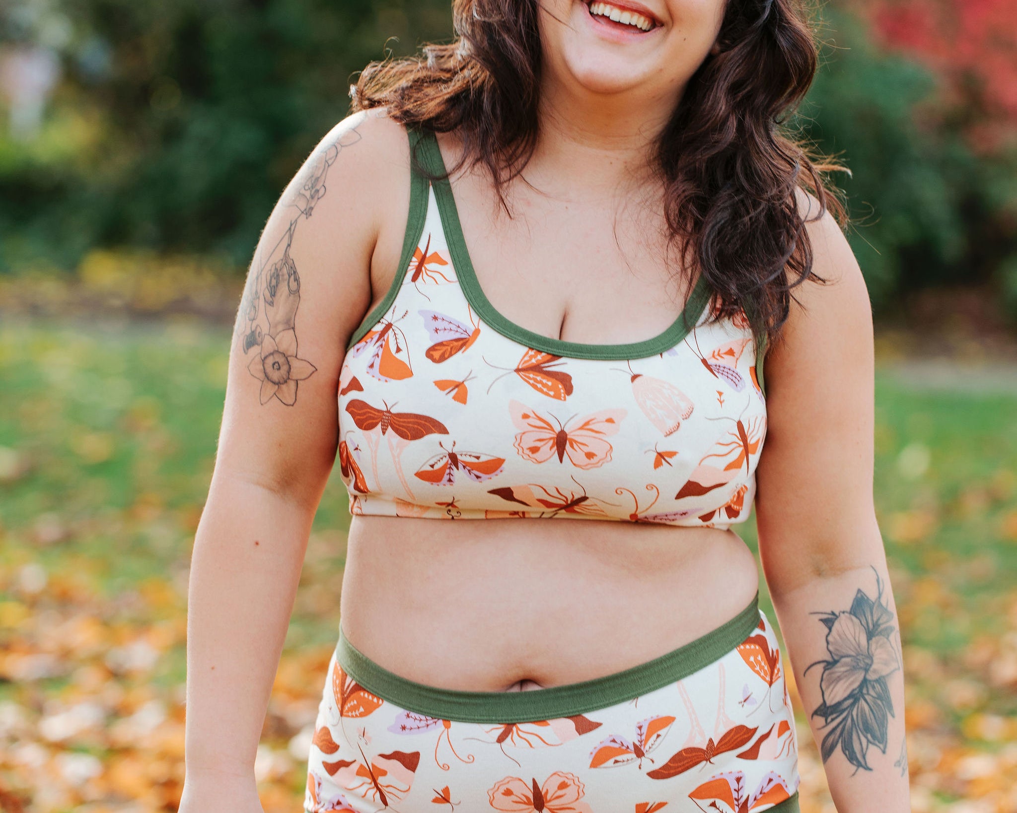Model wearing Thunderpants Original style underwear and Longline Bra in Field Study: a moth print in red, orange, pink, and purple bound in green.