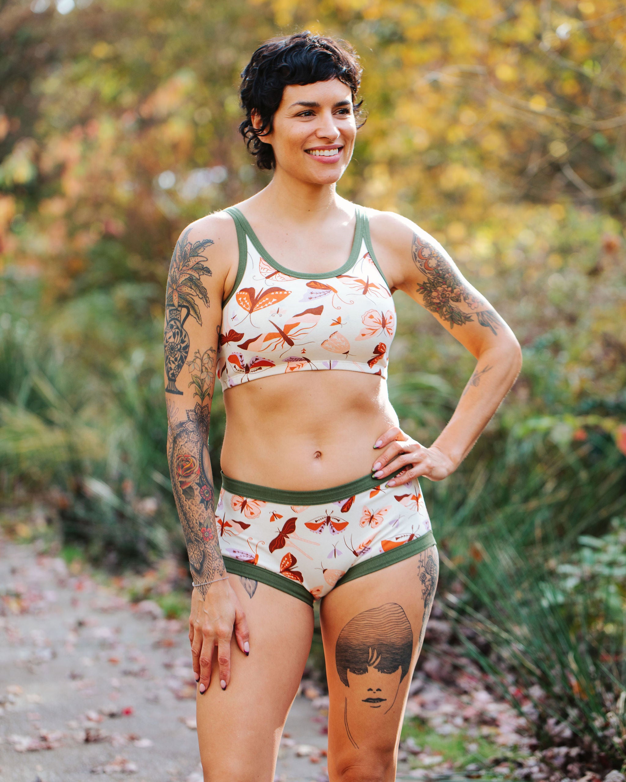 Model wearing Thunderpants Original style underwear and Longline Bra in Field Study: a moth print in red, orange, pink, and purple bound in green.