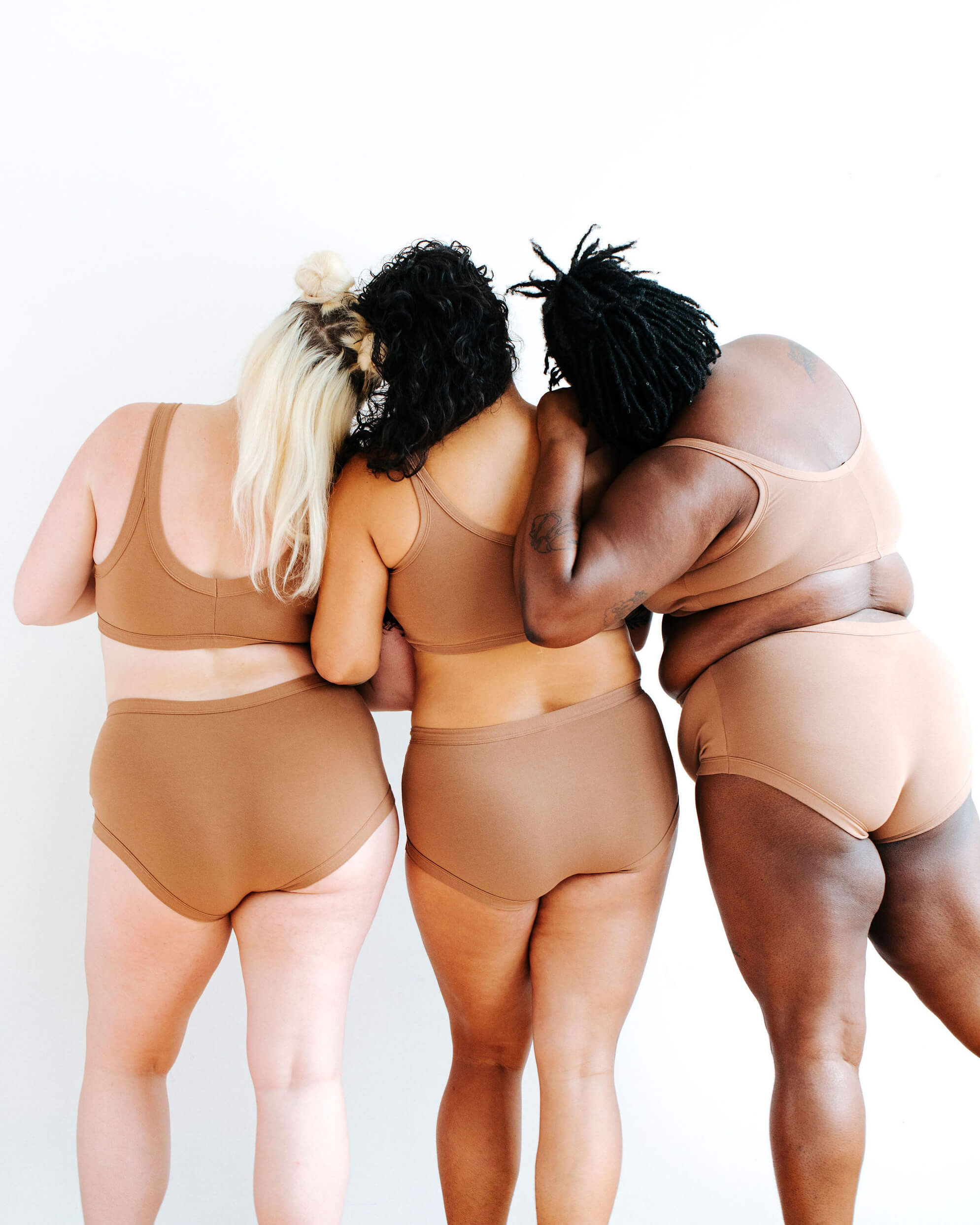 Three models wearing Thunderpants Original style underwear and Longline Bra sets in Hazelnut color.