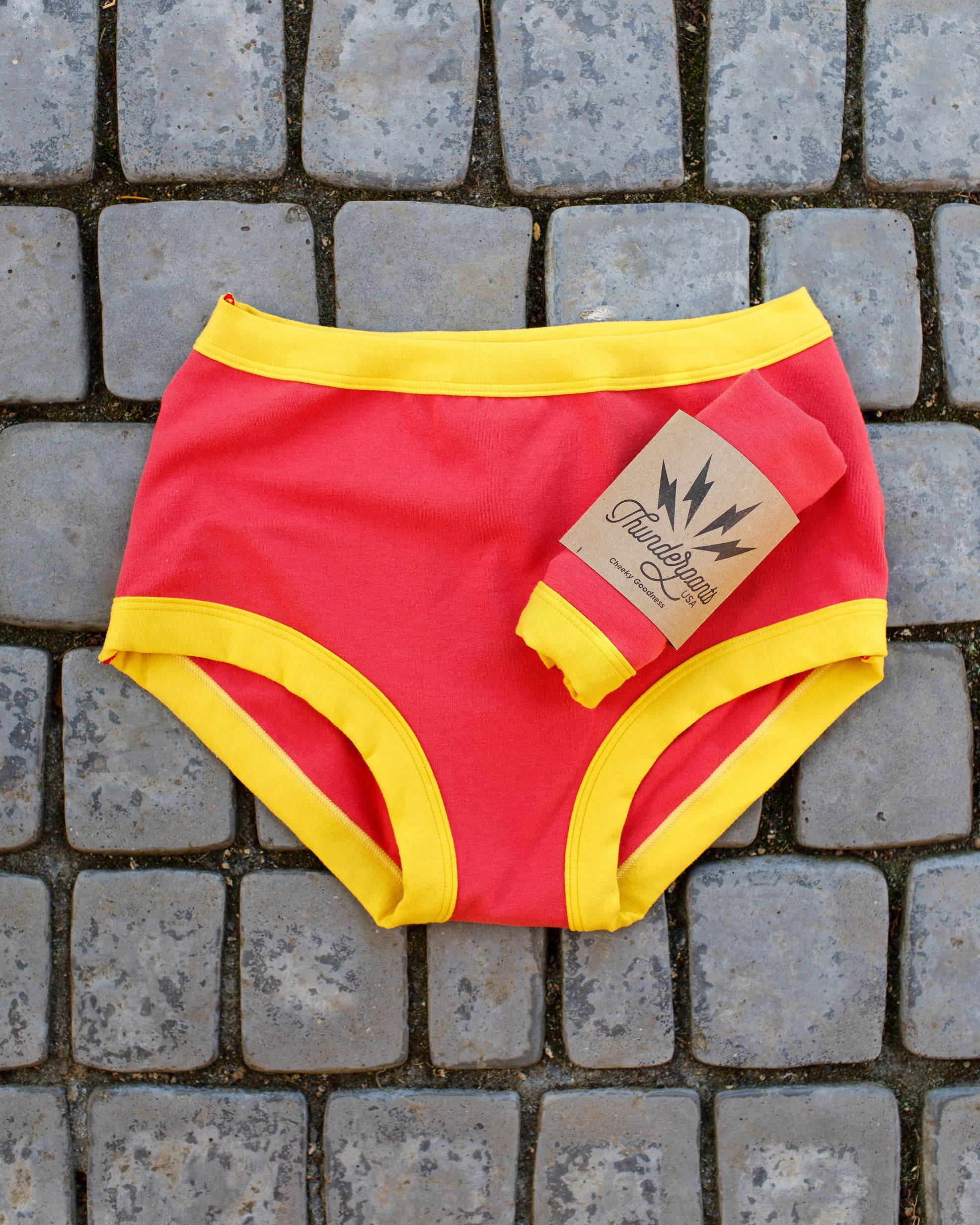 Flat lay of Thunderpants Original style underwear in pink with yellow binding.