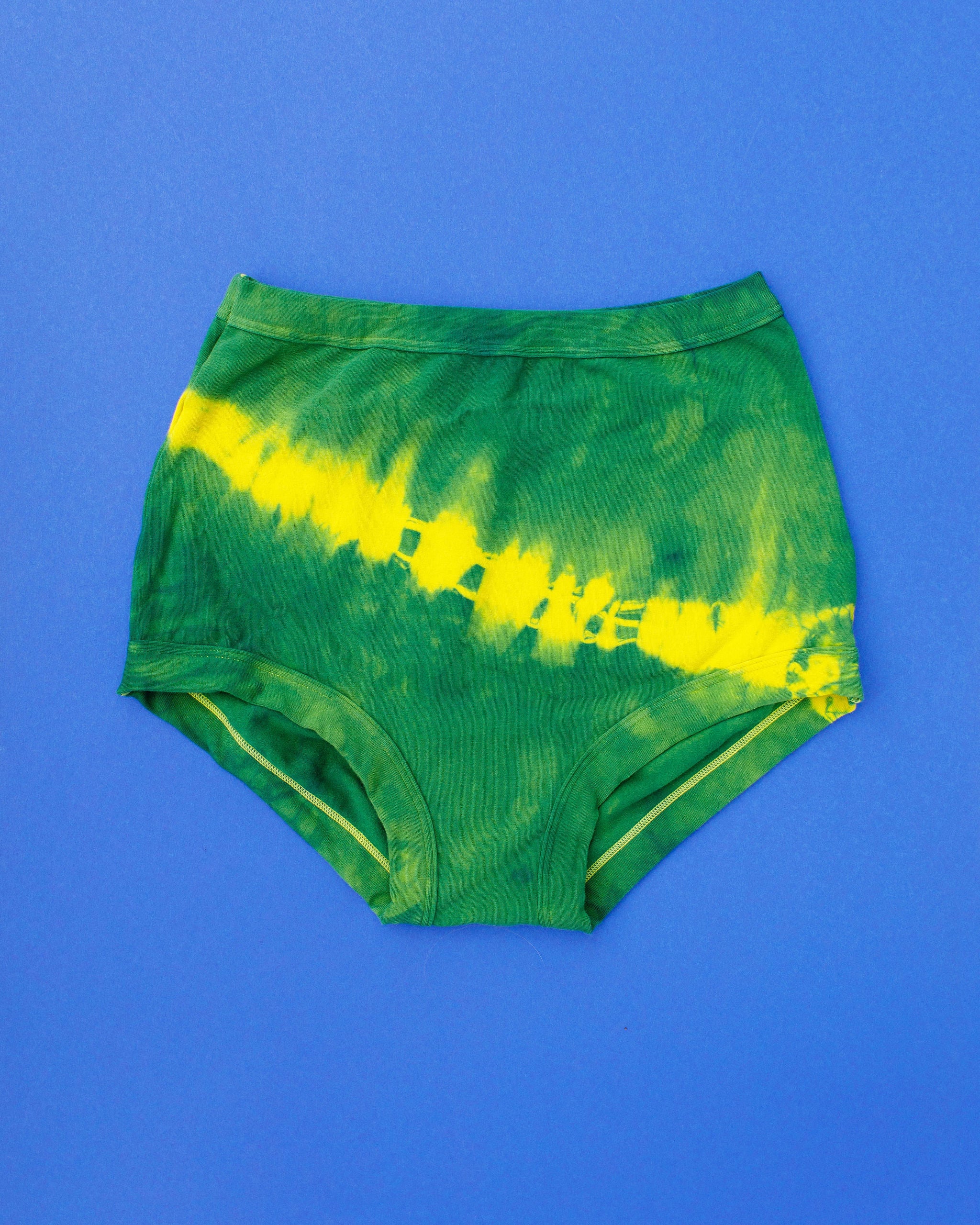 Flat lay of Thunderpants Sky Rise style underwear in Lightning Bolt hand dye - blue/green with yellow stripe.