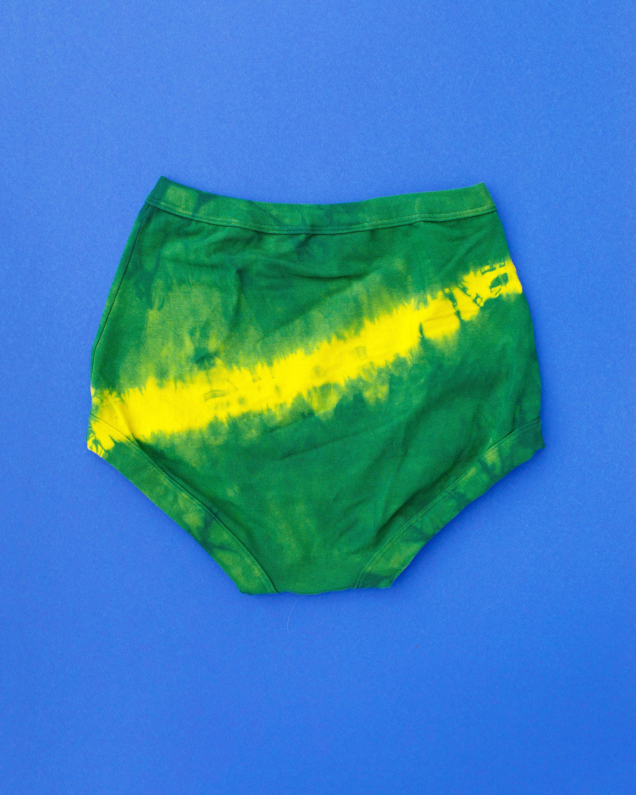 Flat lay of Thunderpants Sky Rise style underwear in Lightning Bolt hand dye - blue/green with yellow stripe.