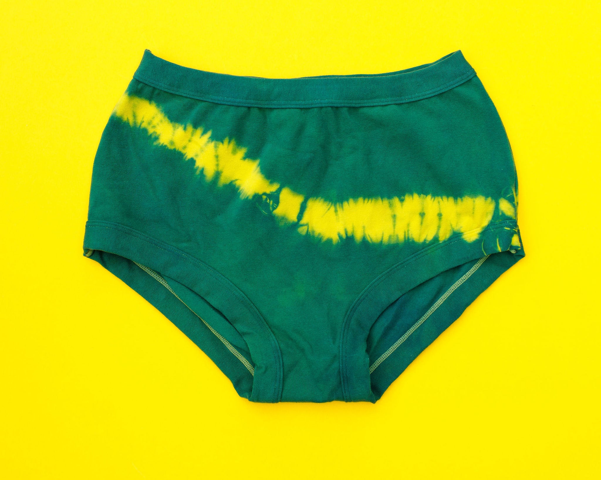 Flat lay of Thunderpants Original style underwear in Lightning Bolt hand dye - blue/green with yellow stripe.