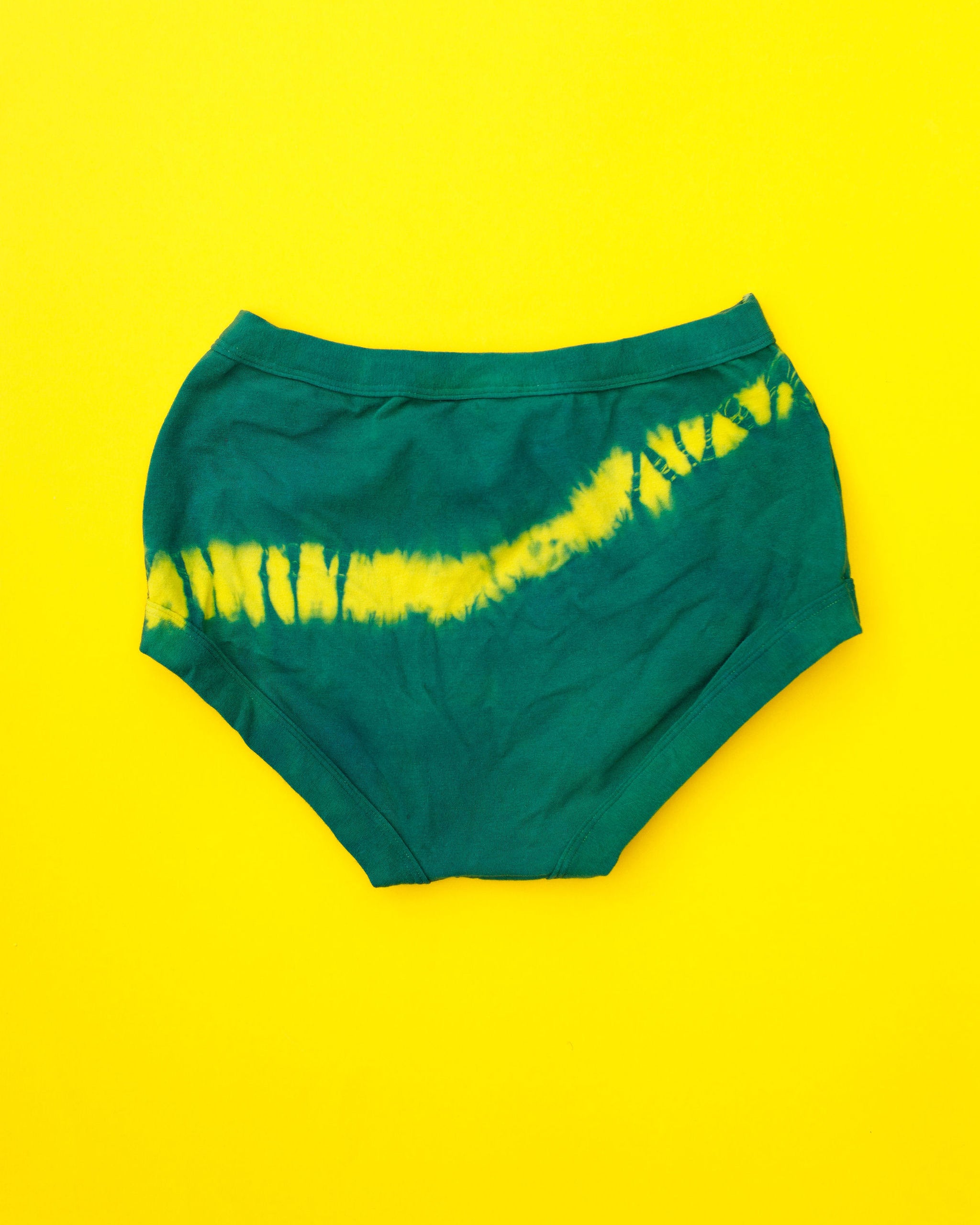 Flat lay of Thunderpants Original style underwear in Lightning Bolt hand dye - blue/green with yellow stripe.