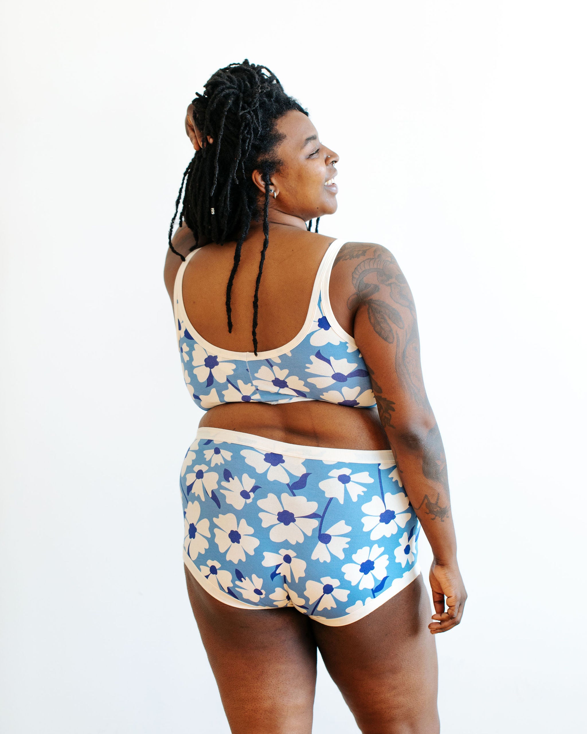 Model wearing Thunderpants Original style underwear and Bralette in Moody Blooms - white and blue flowers with blue background.