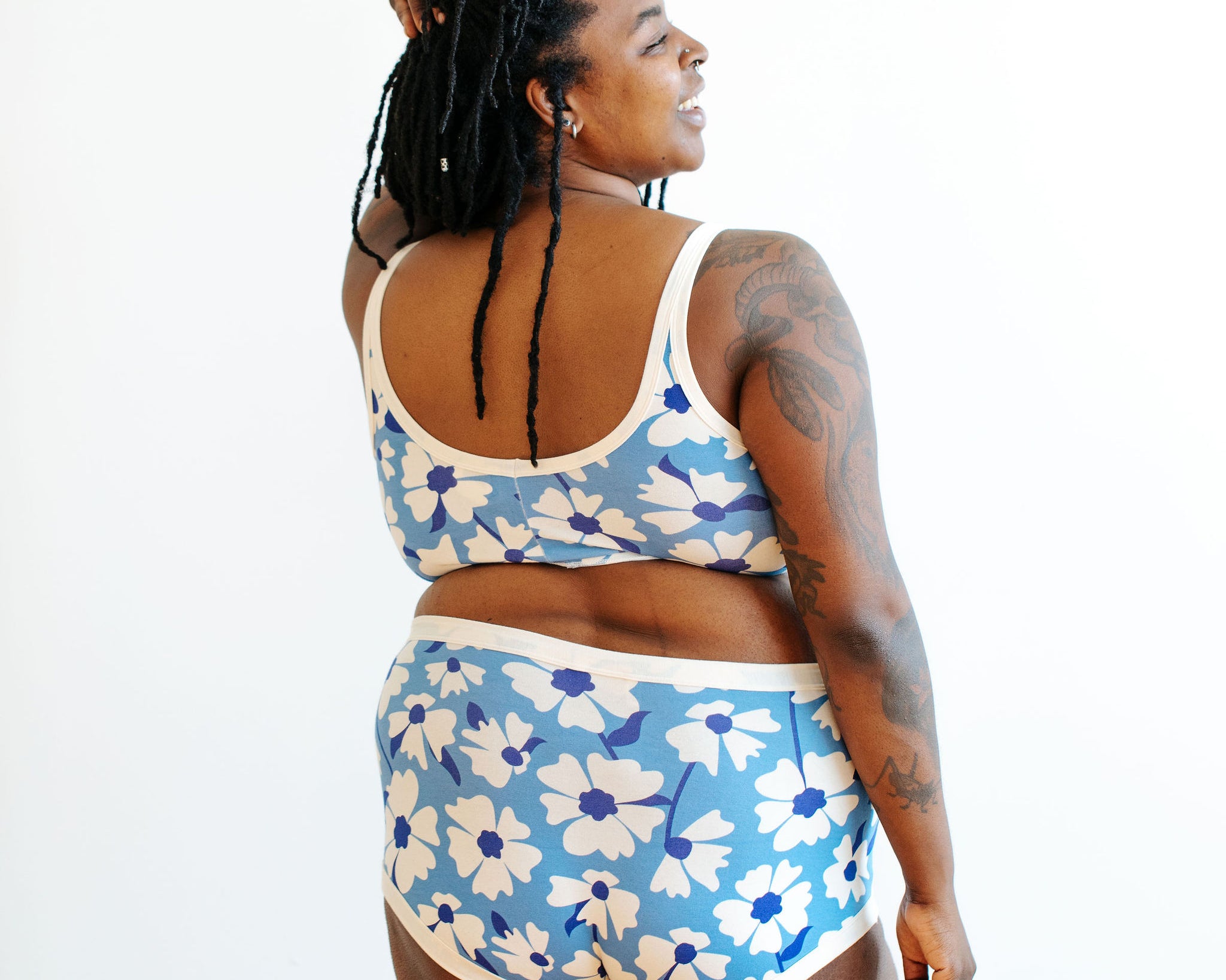 Model wearing Thunderpants Original style underwear and Bralette in Moody Blooms - white and blue flowers with blue background.