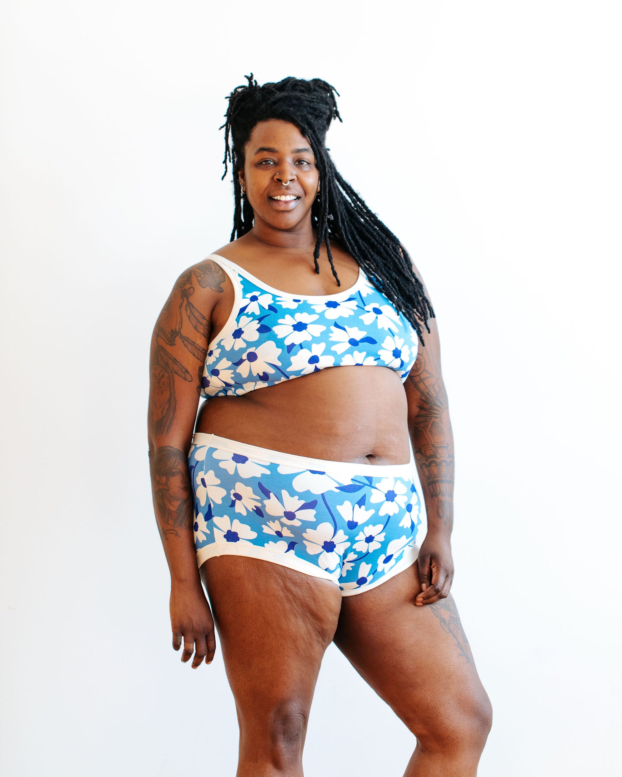 Model wearing Thunderpants Original style underwear and Bralette in Moody Blooms - white and blue flowers with blue background.