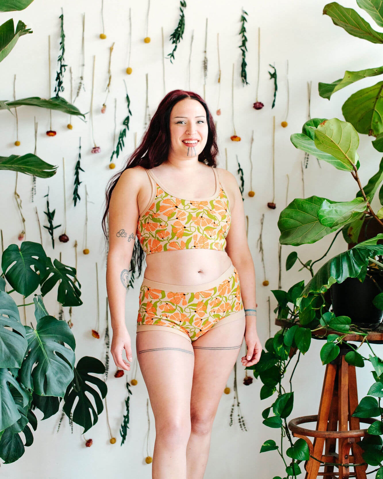 Model wearing a set of Thunderpants Original style underwear  and Longline Bra in Secret Garden print - orange flowers and green leaves.