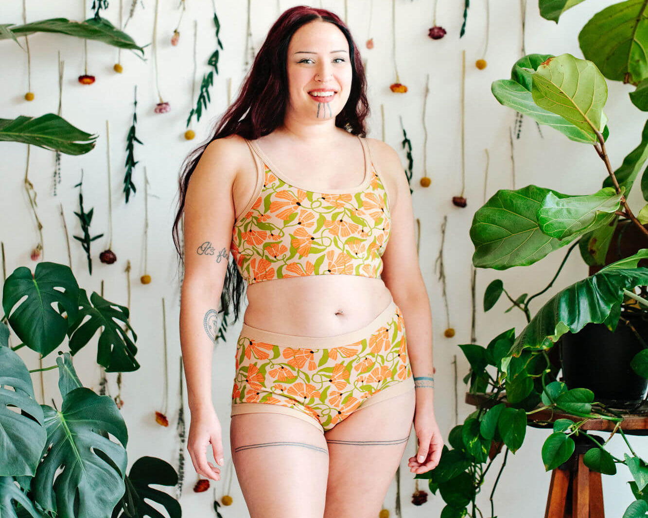 Model wearing a set of Thunderpants Original style underwear  and Longline Bra in Secret Garden print - orange flowers and green leaves.