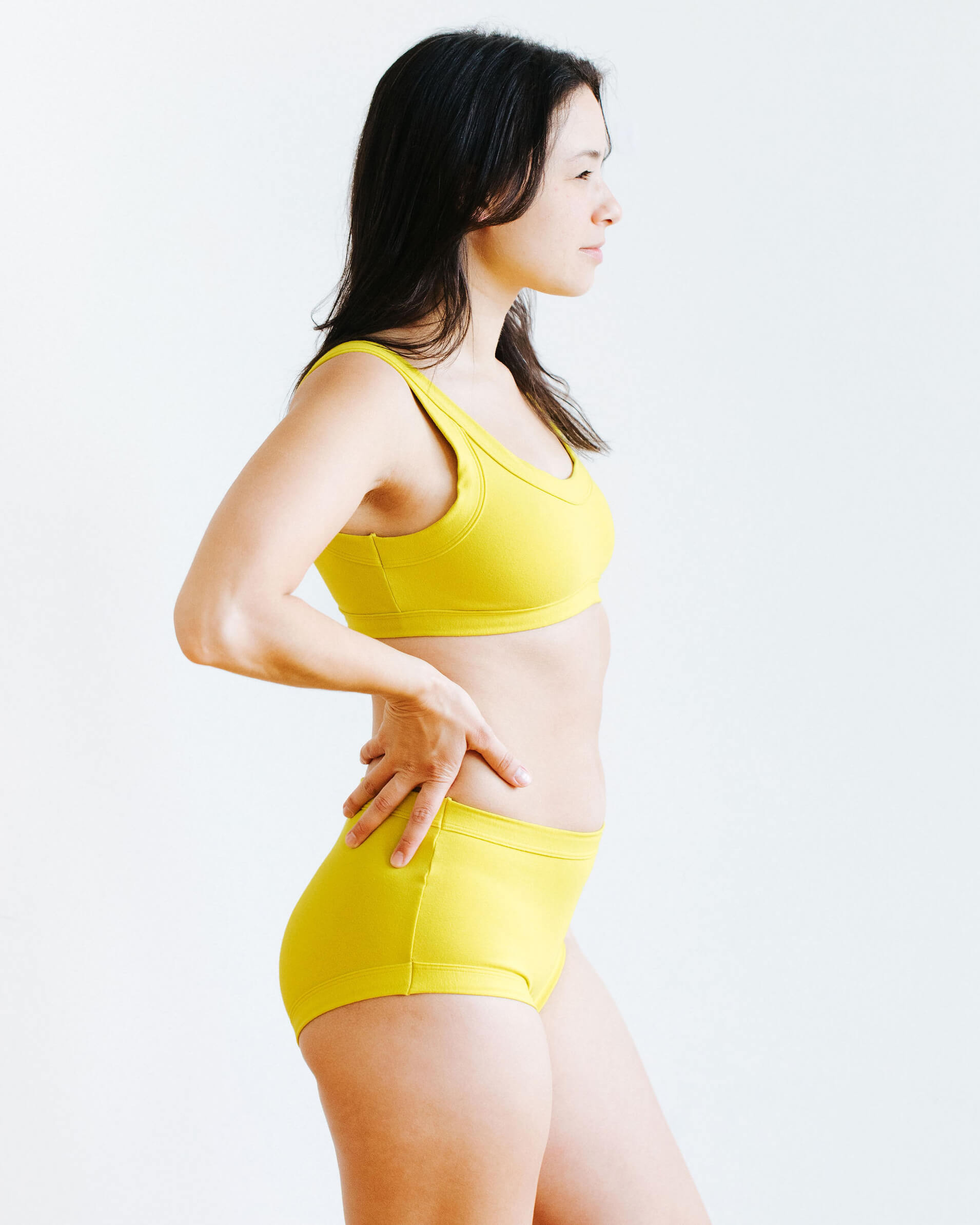 Model wearing Thunderpants Original style underwear and Bralette in Star Fruit color - a chartreuse yellow.