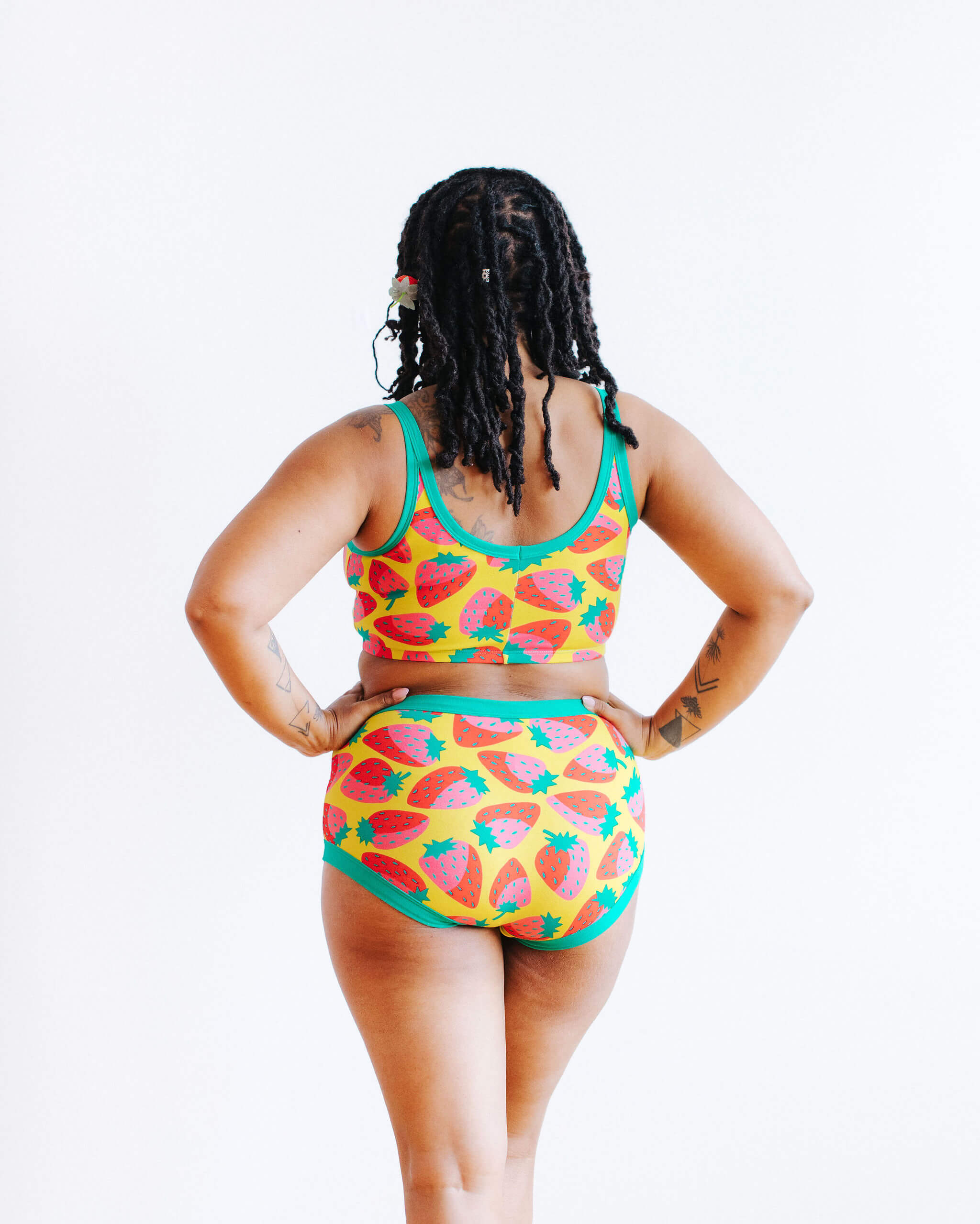 Model wearing Thunderpants Original style underwear and Longline Bra in a Strawberry print - pink, red, and peacock green on chartreuse. 