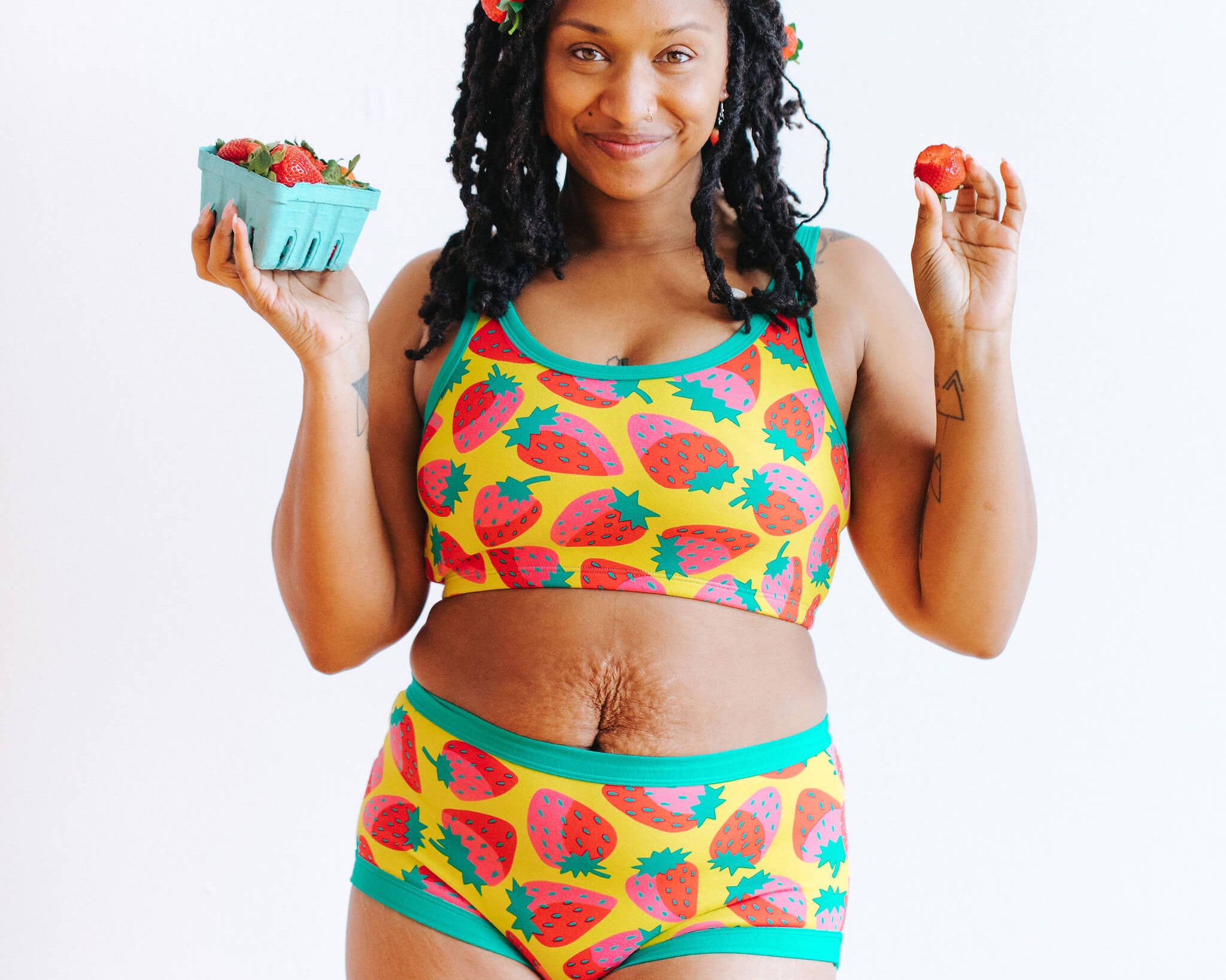 Model wearing Thunderpants Original style underwear and Longline Bra in a Strawberry print - pink, red, and peacock green on chartreuse. 