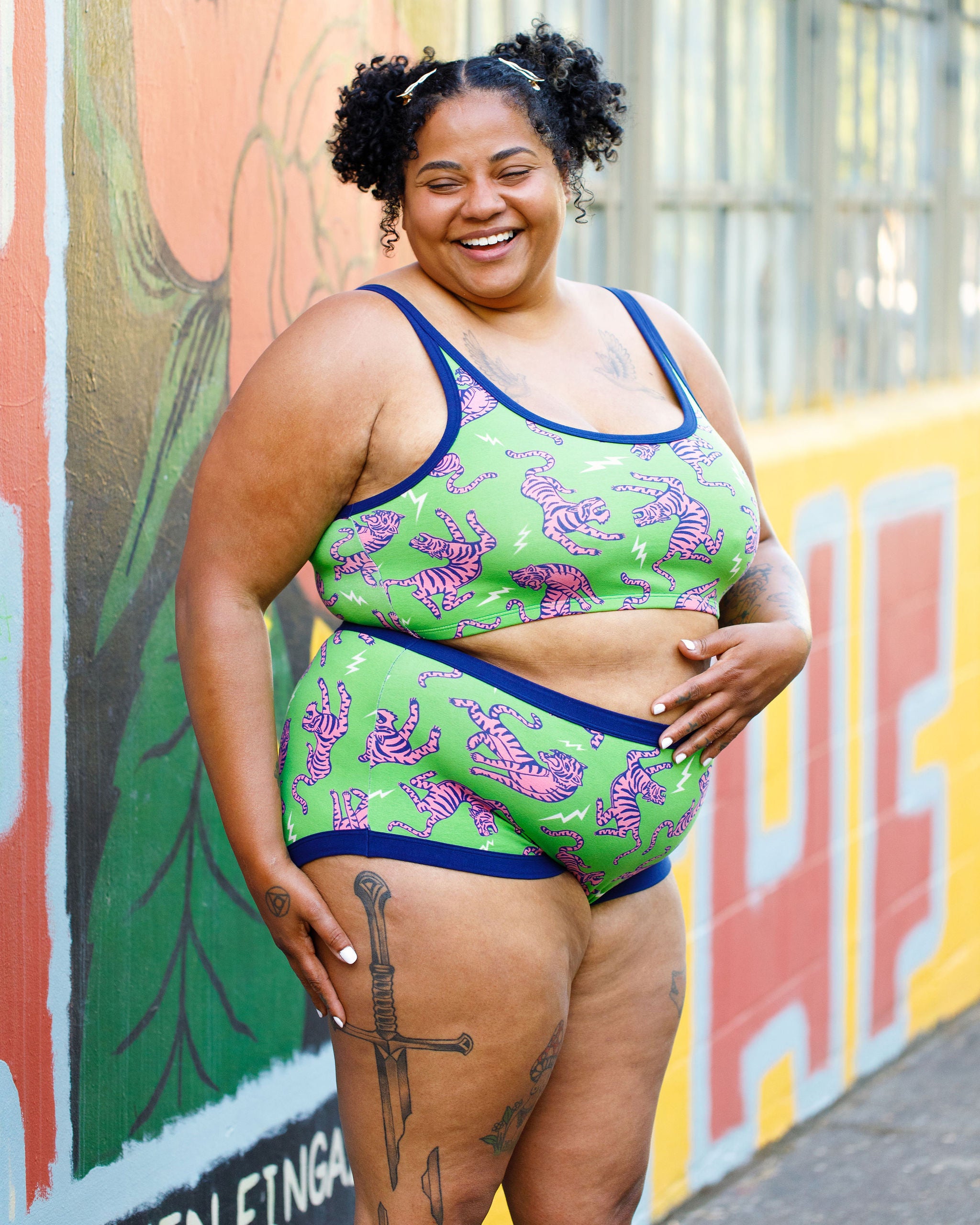 Model wearing Thunderpants organic cotton Original style underwear and Longline Bra in Electric Tiger - green with pink and blue tigers and white lightning bolts.
