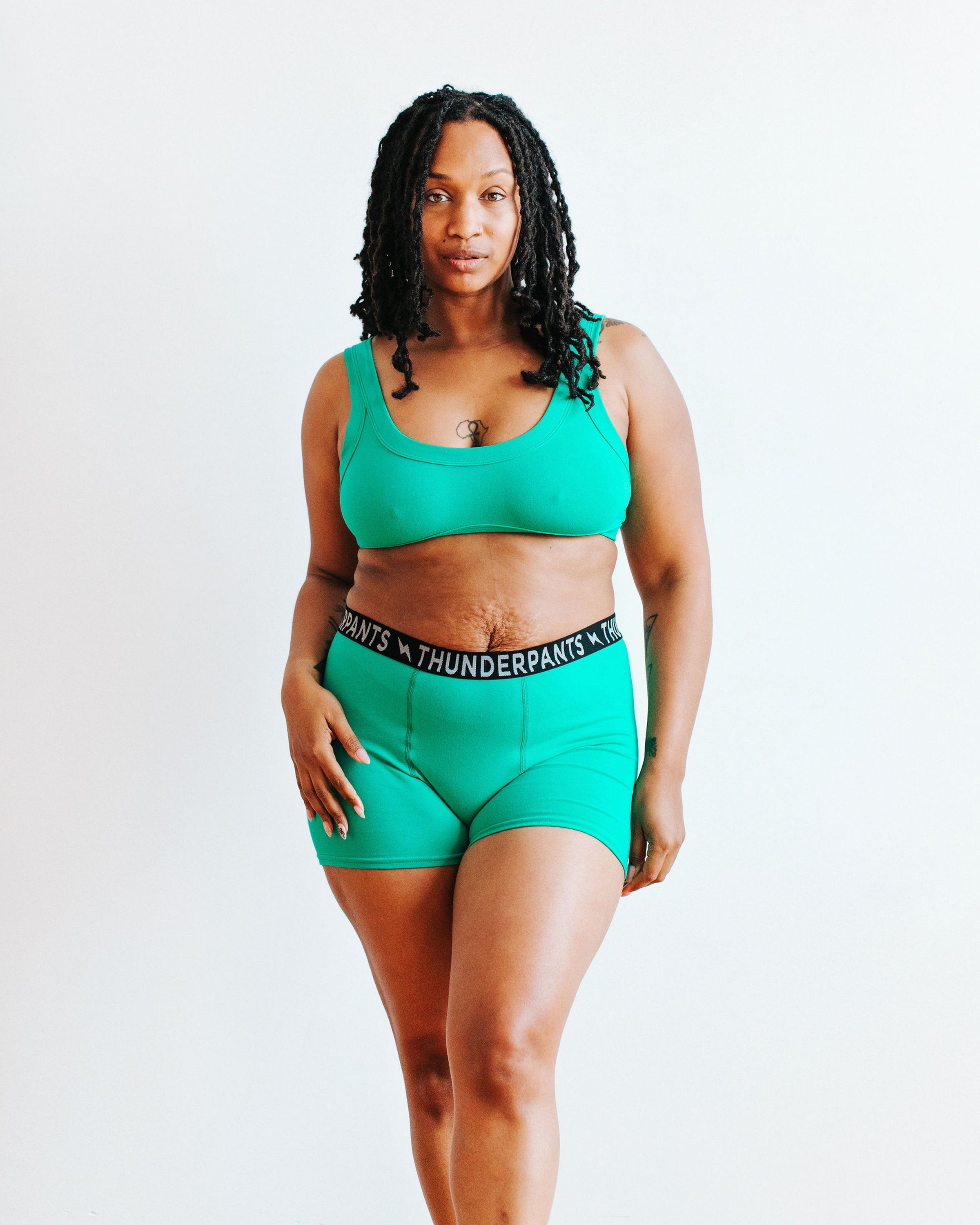 Model wearing Thunderpants Boxer Brief style underwear and Bralette in Peacock Green.