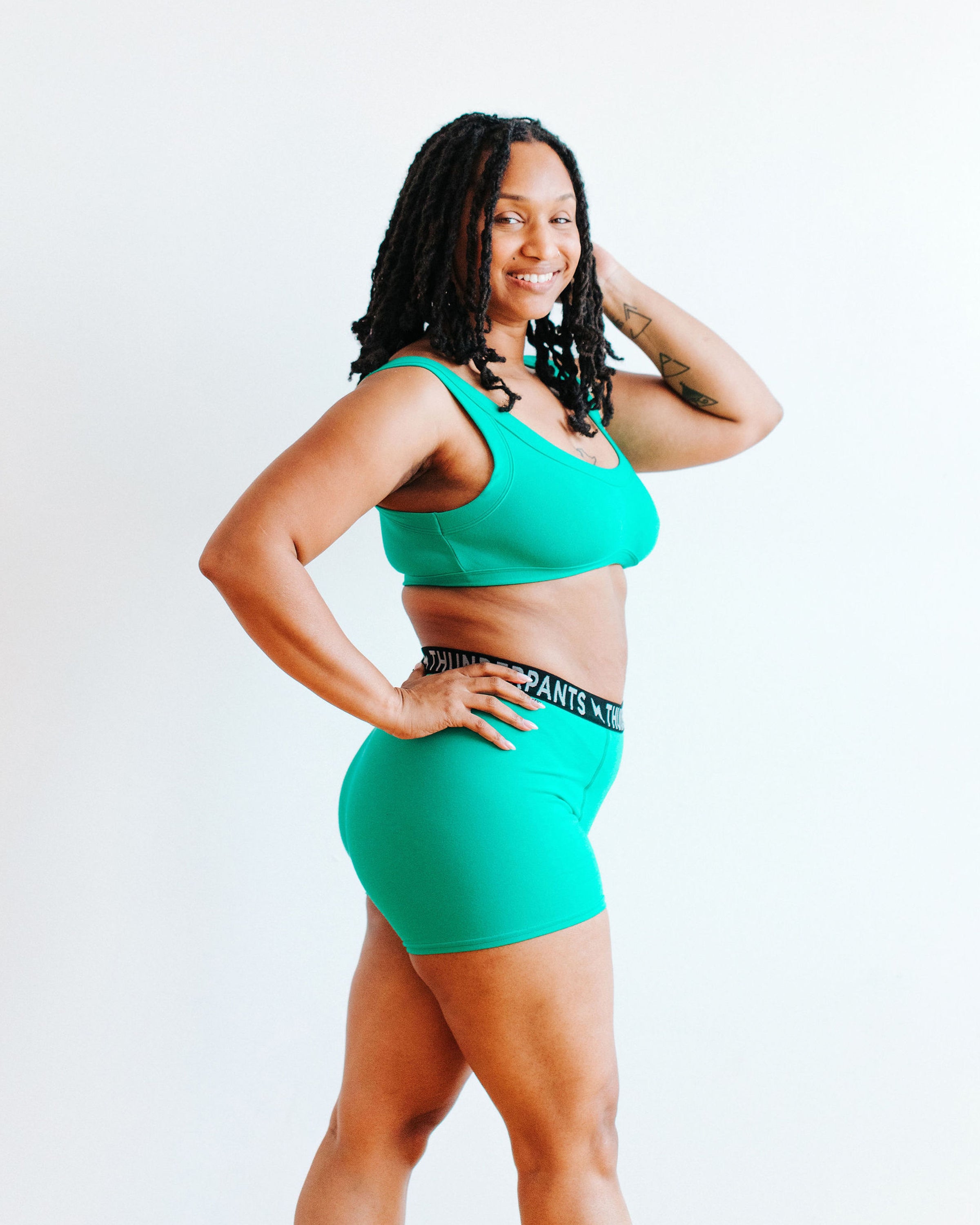Model wearing Thunderpants Boxer Brief style underwear and Bralette in Peacock Green.