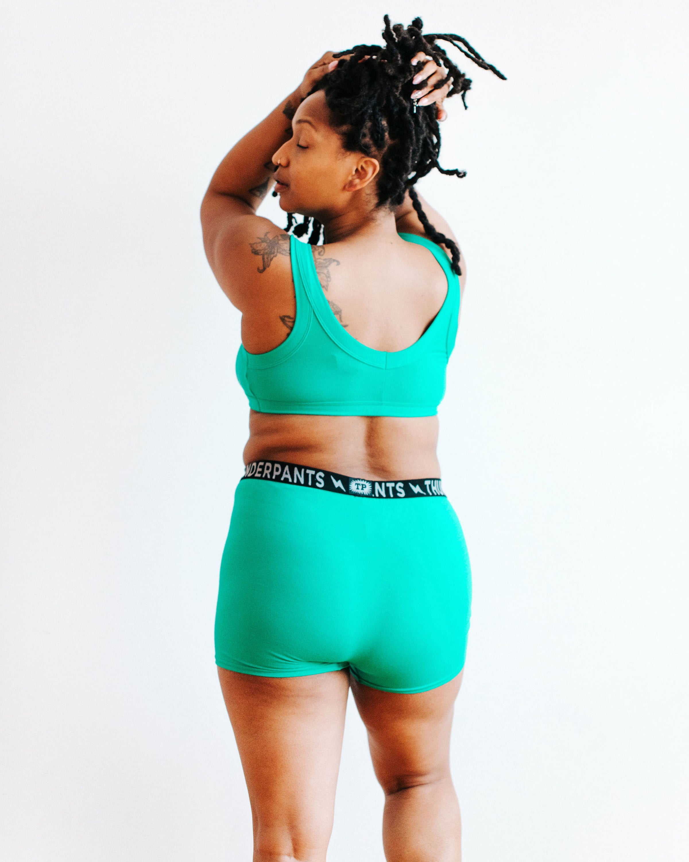 Model wearing Thunderpants Boxer Brief style underwear and Bralette in Peacock Green.