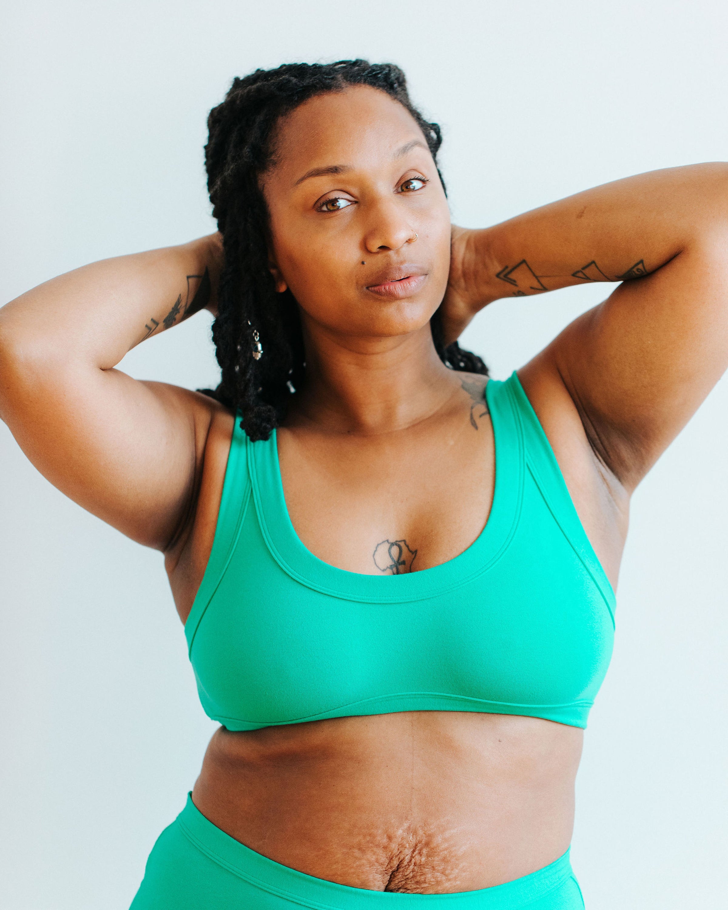Model wearing Thunderpants Bralette in Peacock Green.
