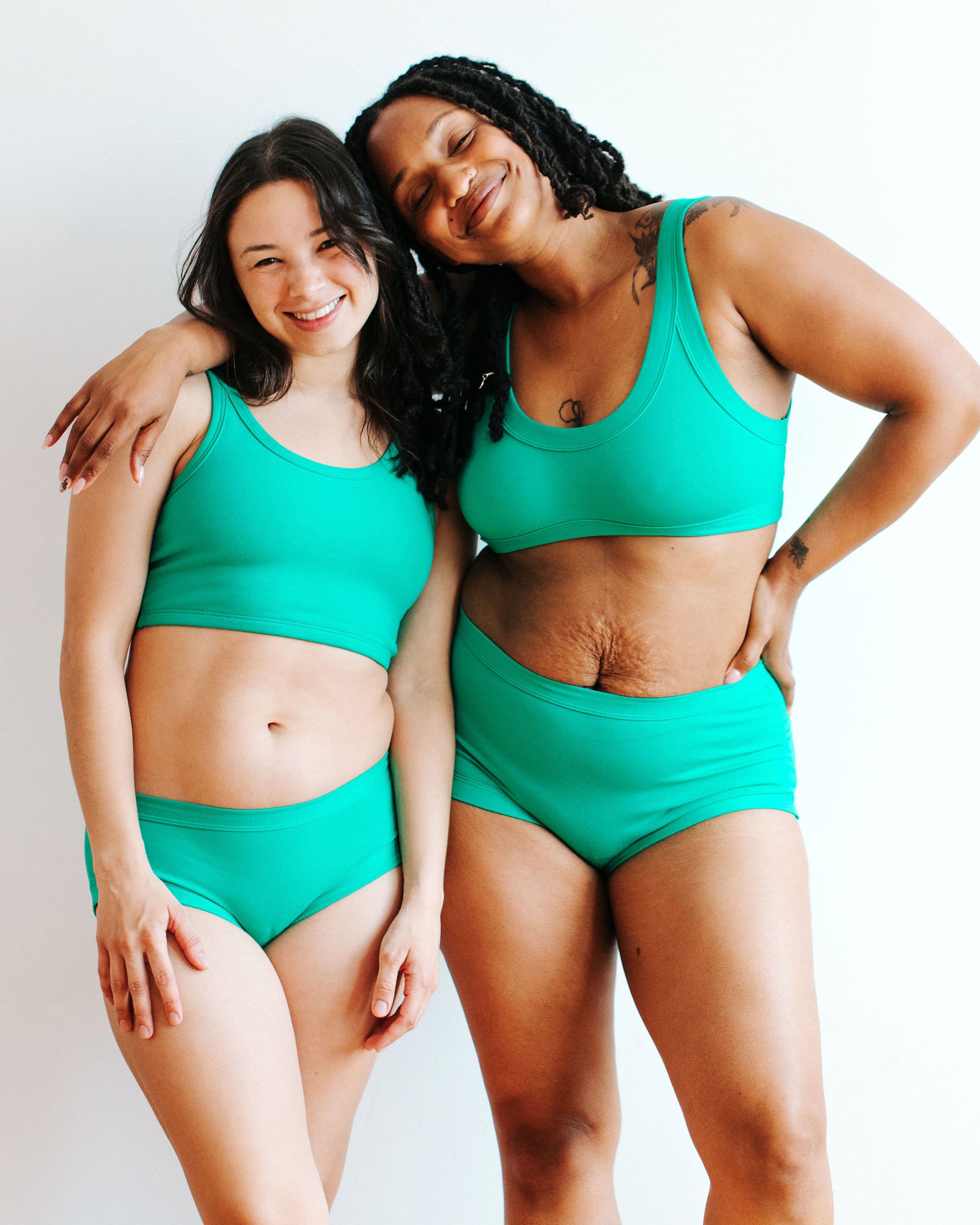 Two models wearing various styles of Thunderpants in Peacock Green.
