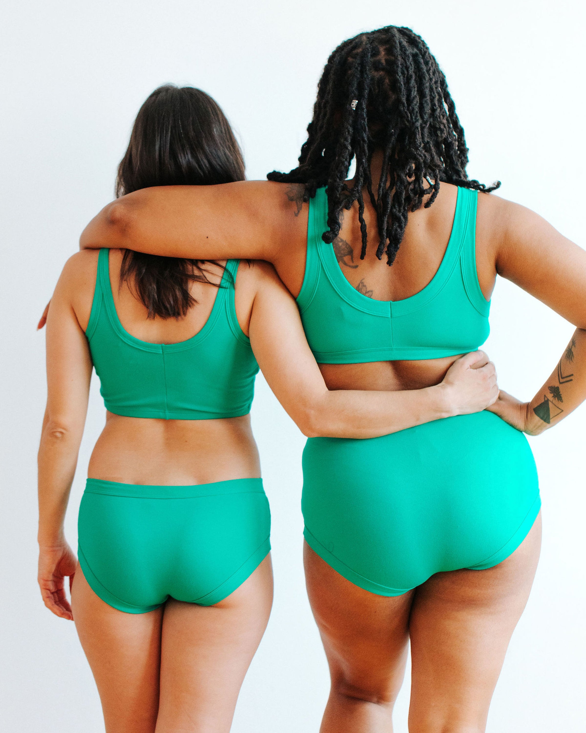 Two models wearing various styles of Thunderpants in Peacock Green.