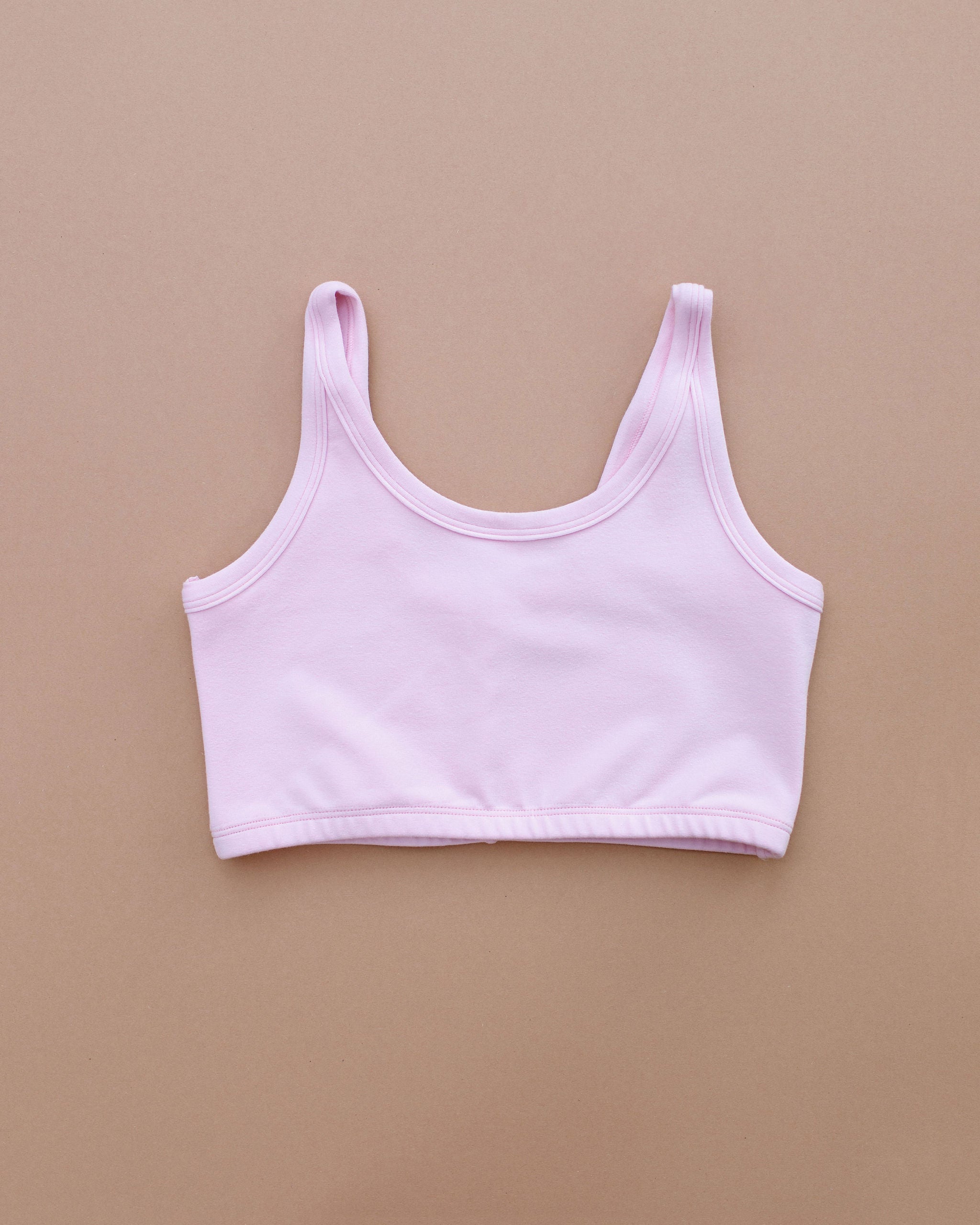 Flat lay of Thunderpants Longline Bra in Plié Pink - light pink color.