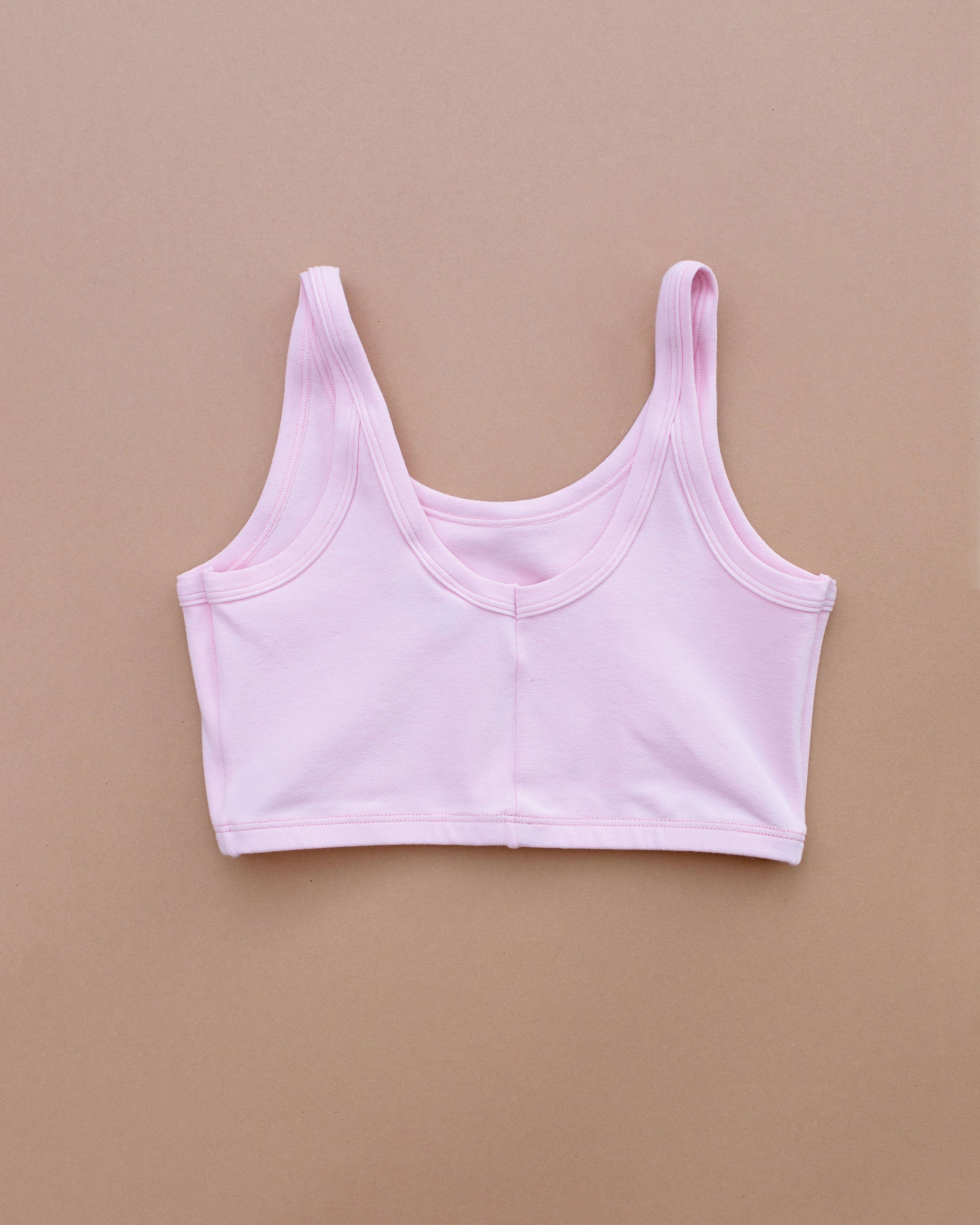 Flat lay of Thunderpants Longline Bra in Plié Pink - light pink color.