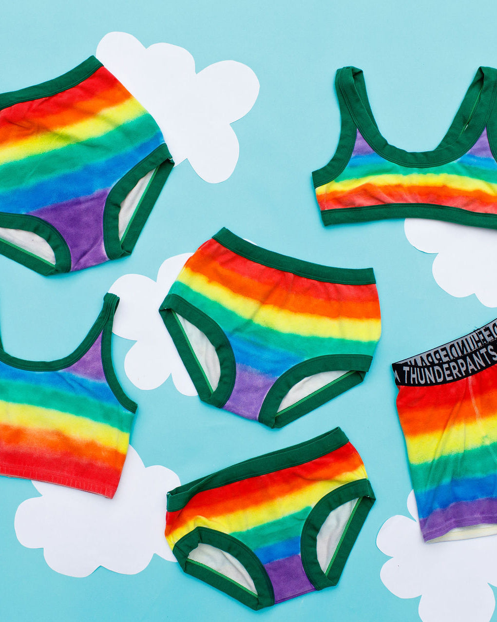 Flat lay of all Thunderpants styles in rainbow dye with emerald green binding.