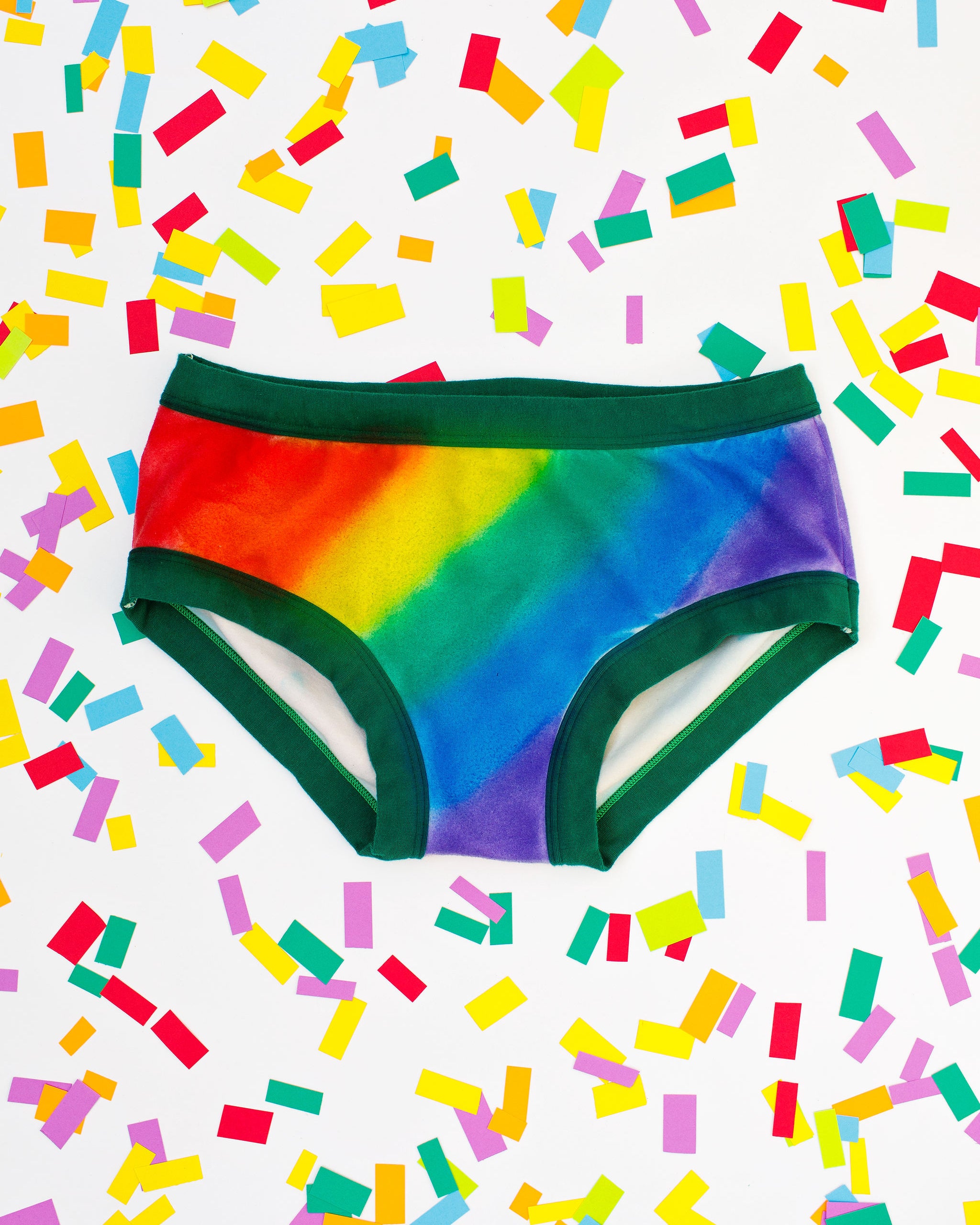 Thunderpants organic cotton Hipster style underwear in hand painted rainbow stripes for Pride laying on rainbow confetti.