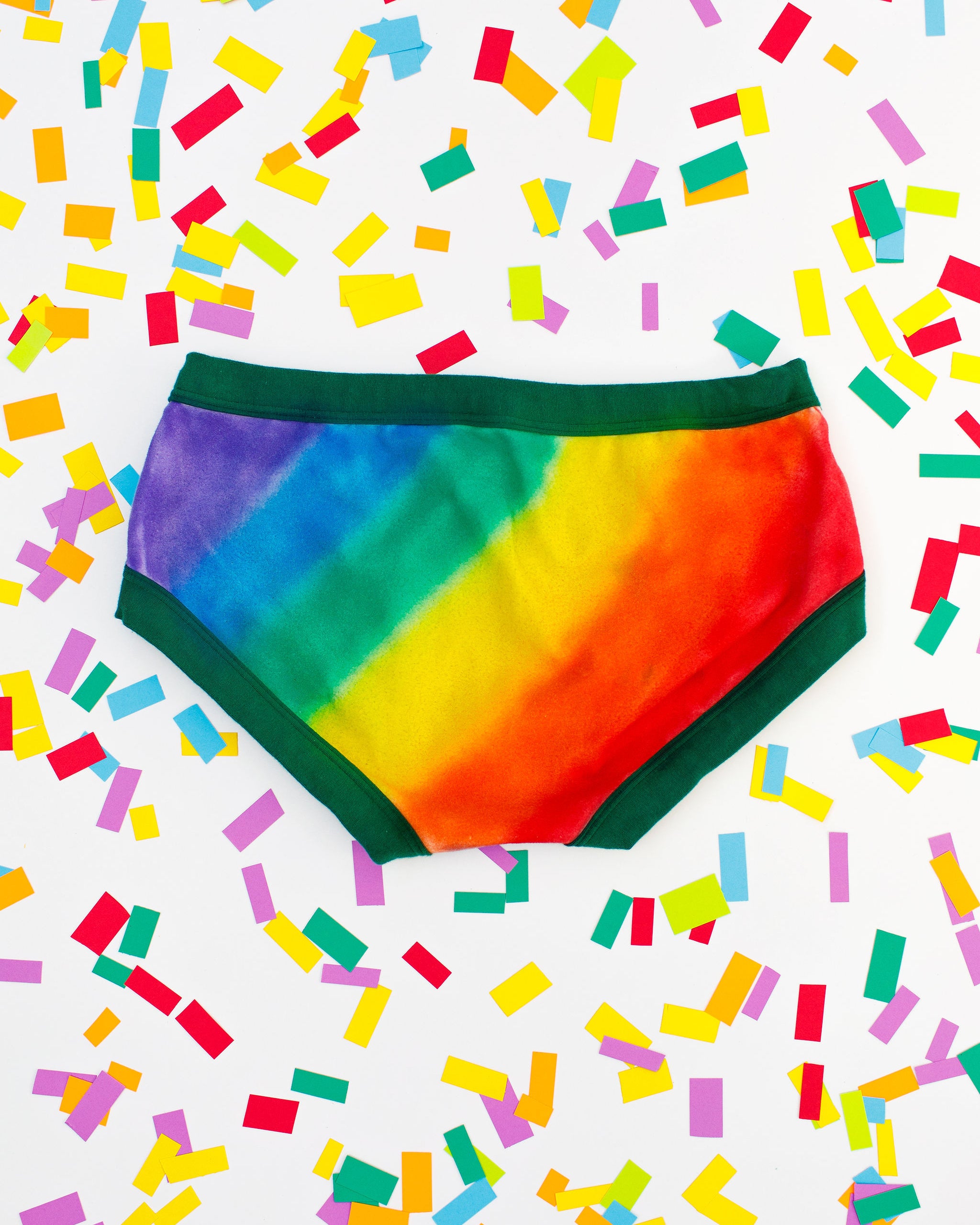 Thunderpants organic cotton Hipster style underwear in hand painted rainbow stripes for Pride laying on rainbow confetti.