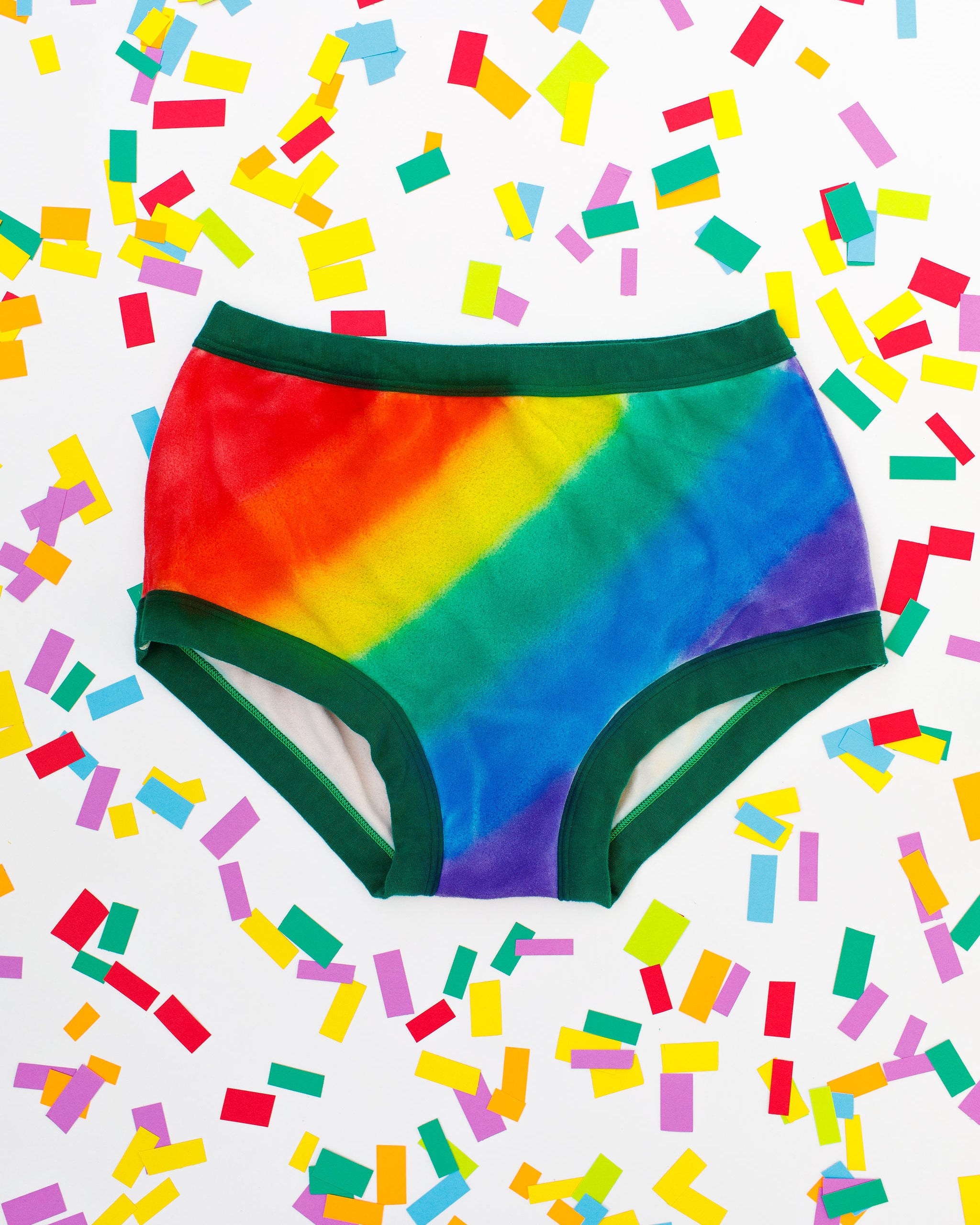 Thunderpants organic cotton Original style underwear in hand painted rainbow stripes for Pride laying on rainbow confetti.