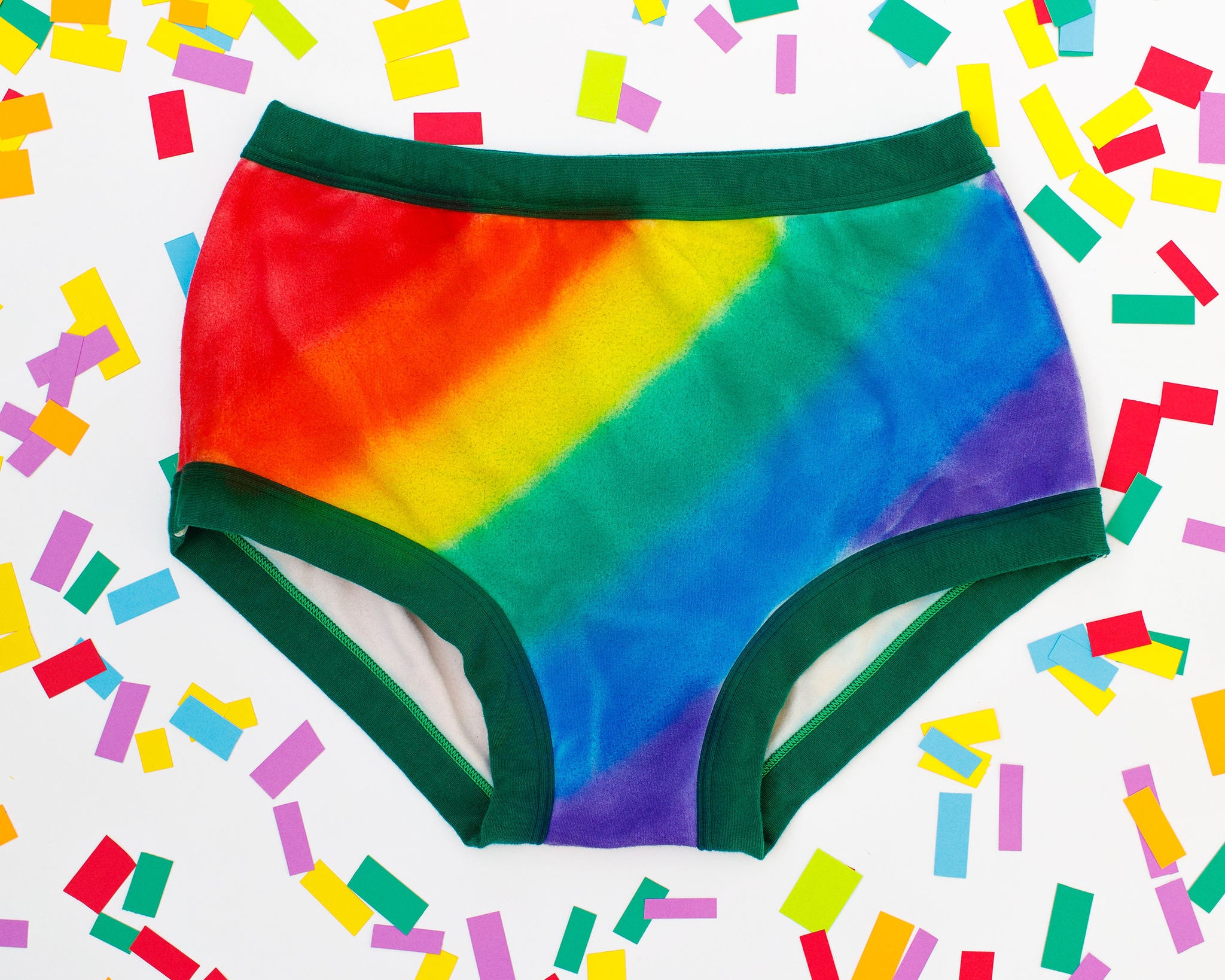 Thunderpants organic cotton Original style underwear in hand painted rainbow stripes for Pride laying on rainbow confetti.
